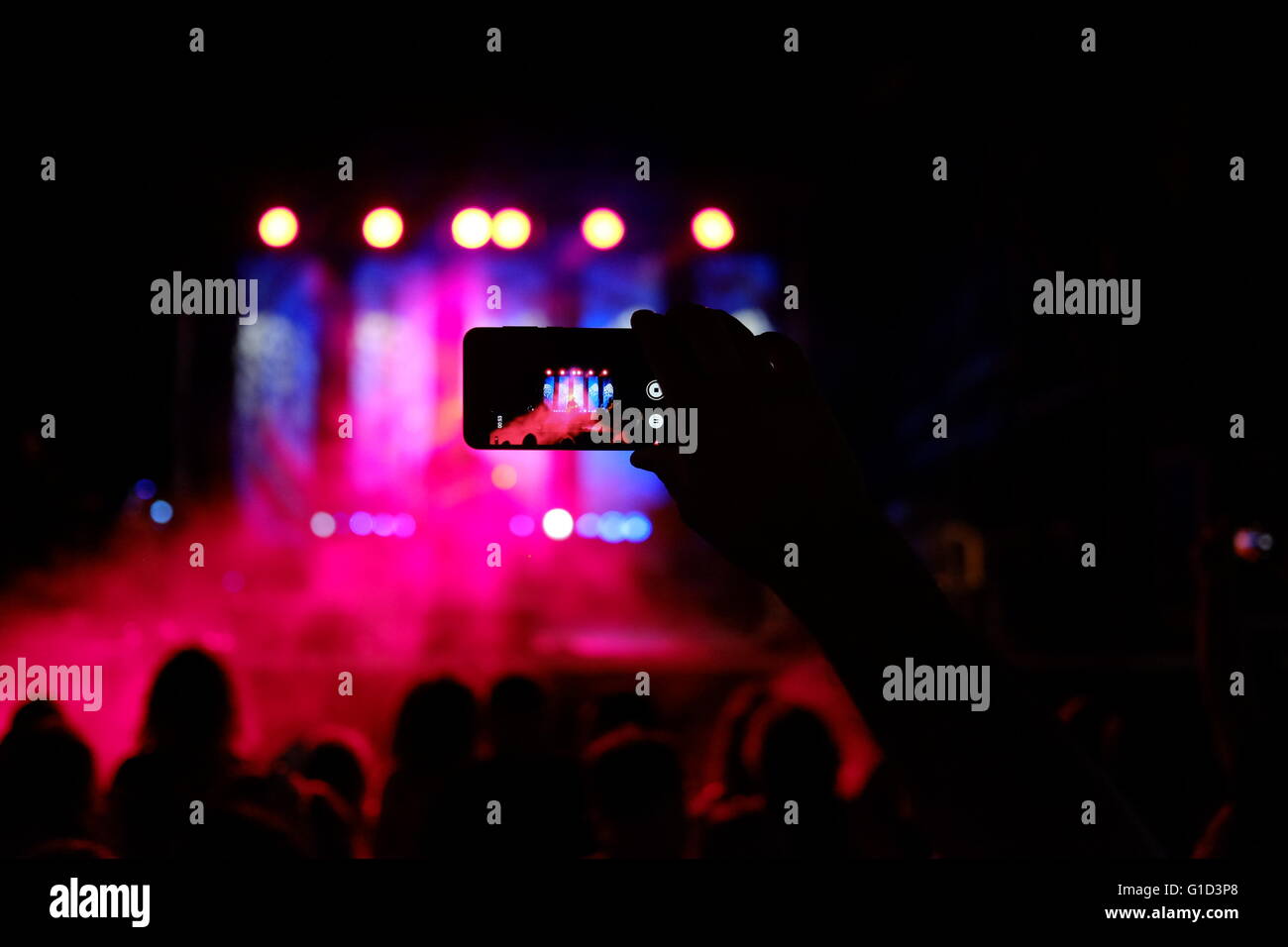 Une personne prenant des photos d'un concert de rock avec un smartphone dans la ville d'Eilat, Israël Banque D'Images