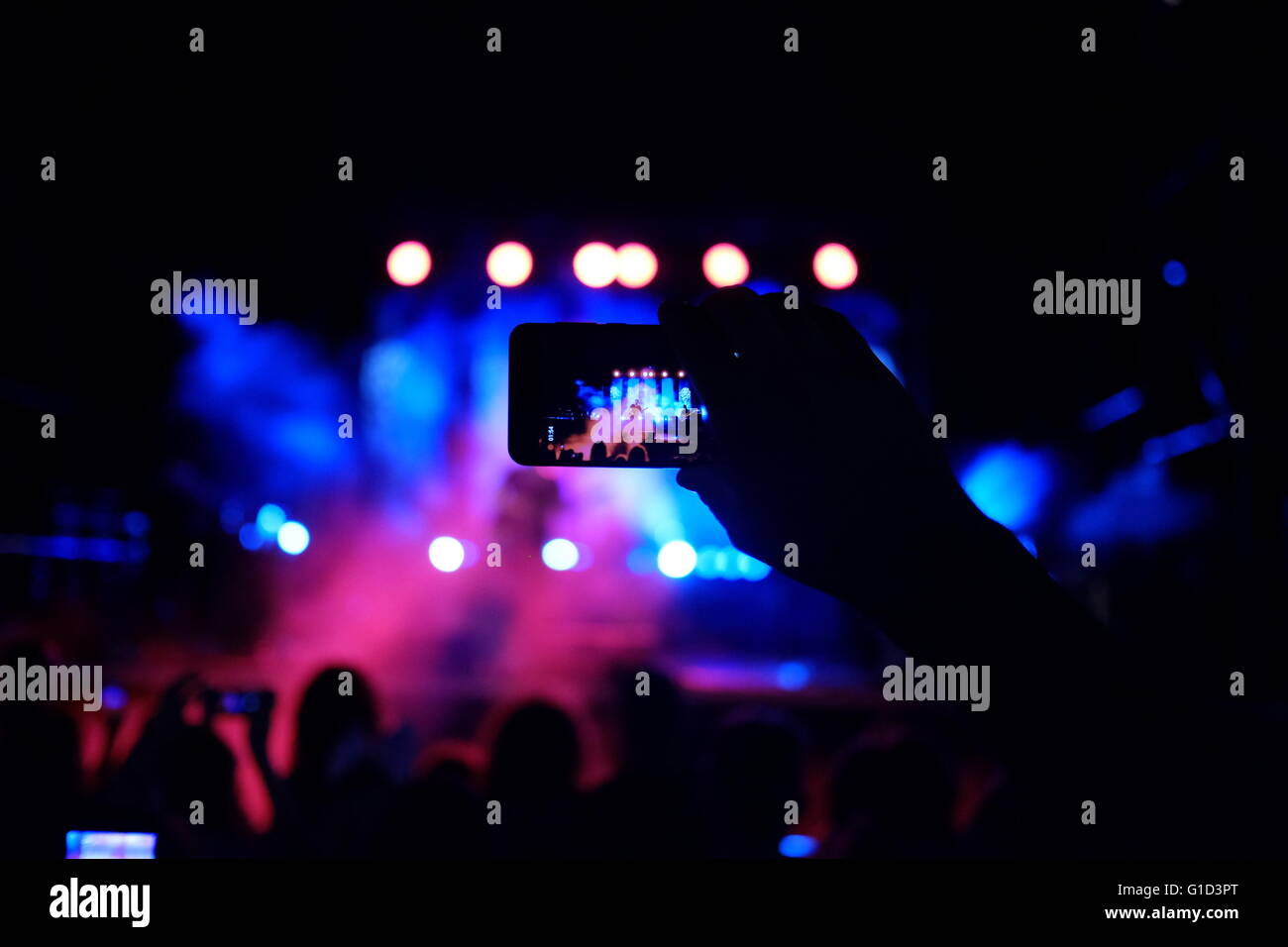 Une personne prenant des photos d'un concert de rock avec un smartphone dans la ville d'Eilat, Israël Banque D'Images