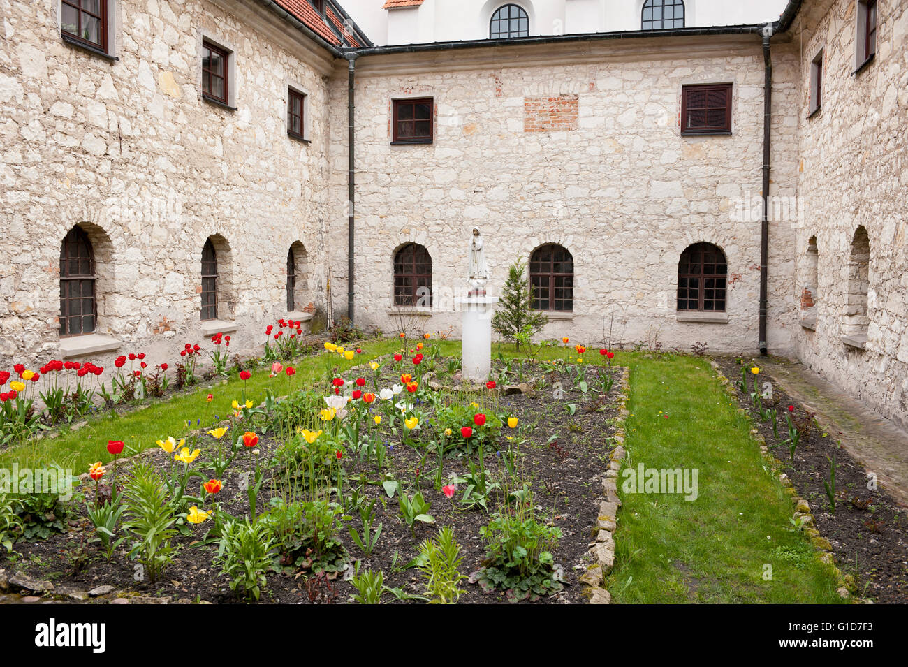 Quadrilatère herbeux entouré par des murs du cloître avec windows, open air monastique jardin d'agrément avec Sainte Mère monument. Banque D'Images