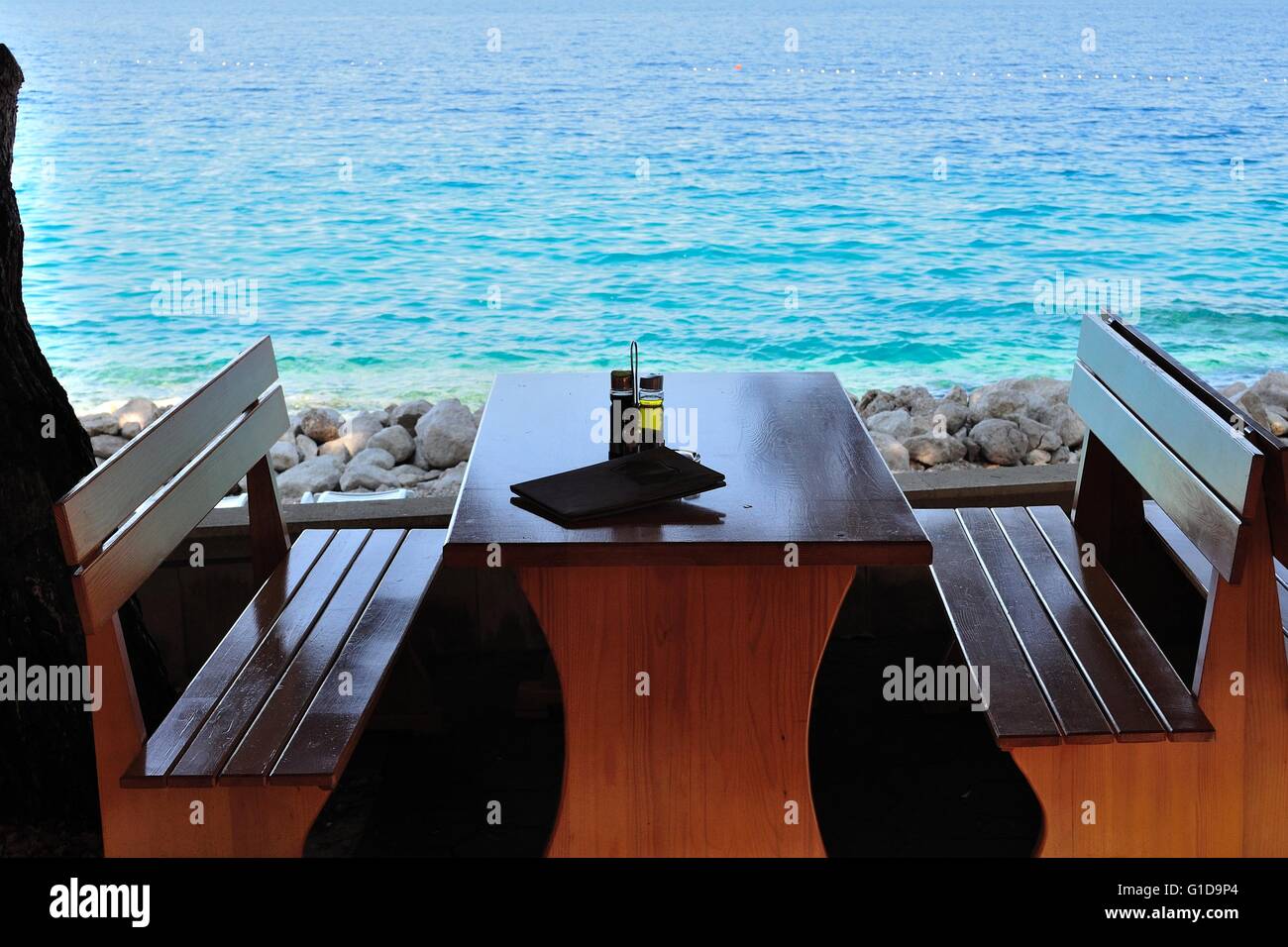 Table avec des bouteilles d'huile d'olive et le vinaigre au Tropical Beach Restaurant, Croatie Banque D'Images