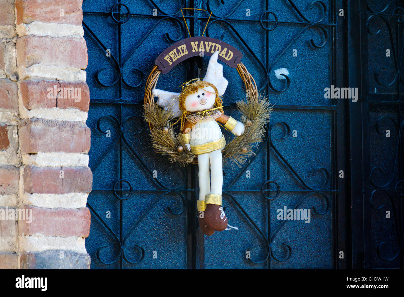 Une couronne de Noël avec une jolie poupée ange est suspendu sur un mur à Todos Santos, Baja Sur, au Mexique. Banque D'Images