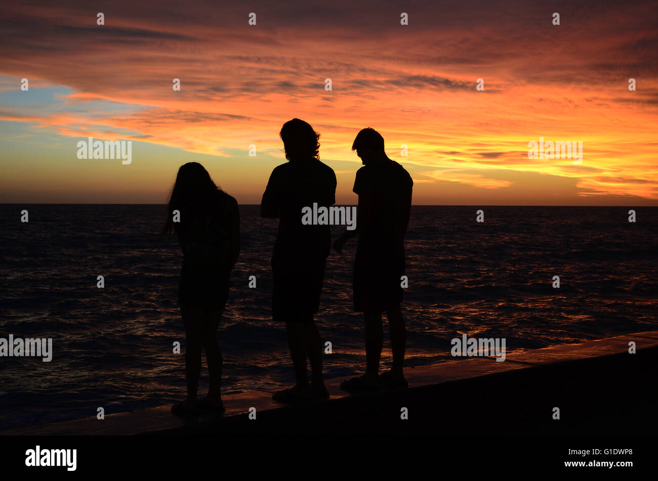 Les jeunes de regarder un coucher de soleil sur la plage de Mazatlan, Sinaloa au Mexique. Banque D'Images