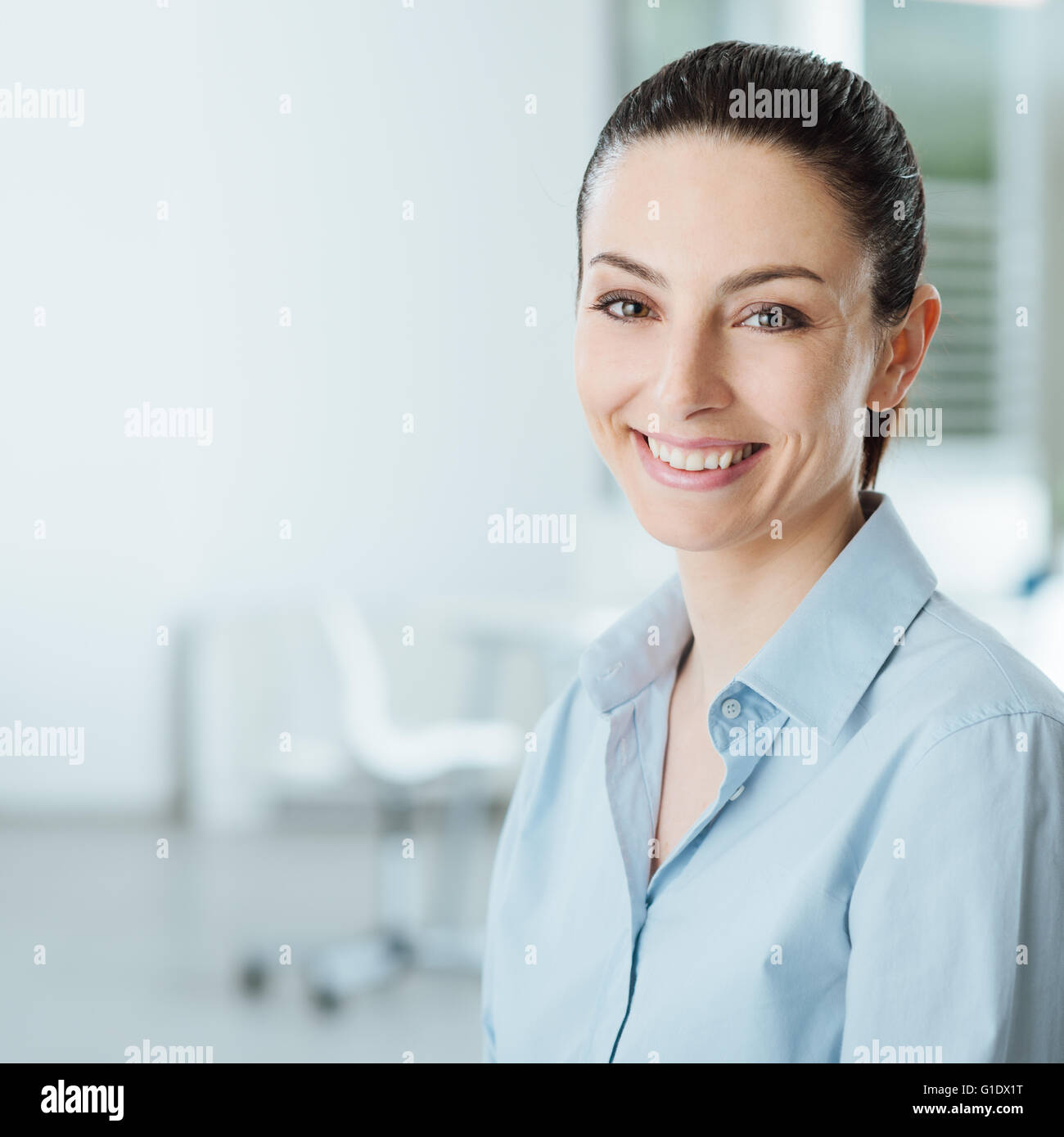 Belle jeune smiling business woman smiling and looking at camera, cabinet intérieur sur l'arrière-plan Banque D'Images