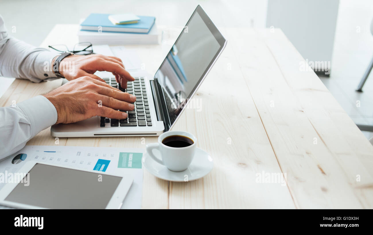Homme d'affaires professionnel travaillant au bureau et la saisie sur un ordinateur portable, personne méconnaissable Banque D'Images