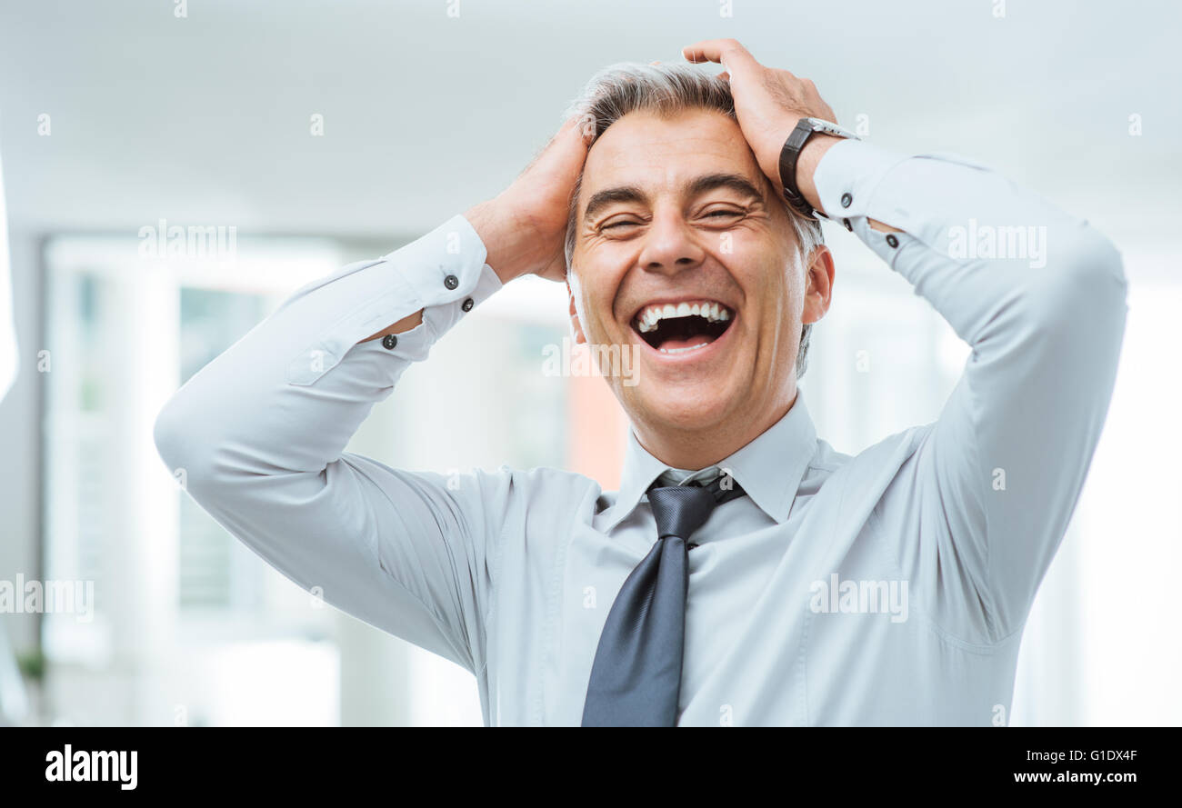 Cheerful businessman laughing imprudente et toucher son front Banque D'Images