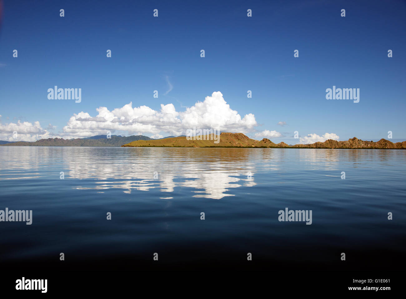 Nuages sur l'île de Pengah reflète dans une mer calme Parc National de Komodo en Indonésie Banque D'Images