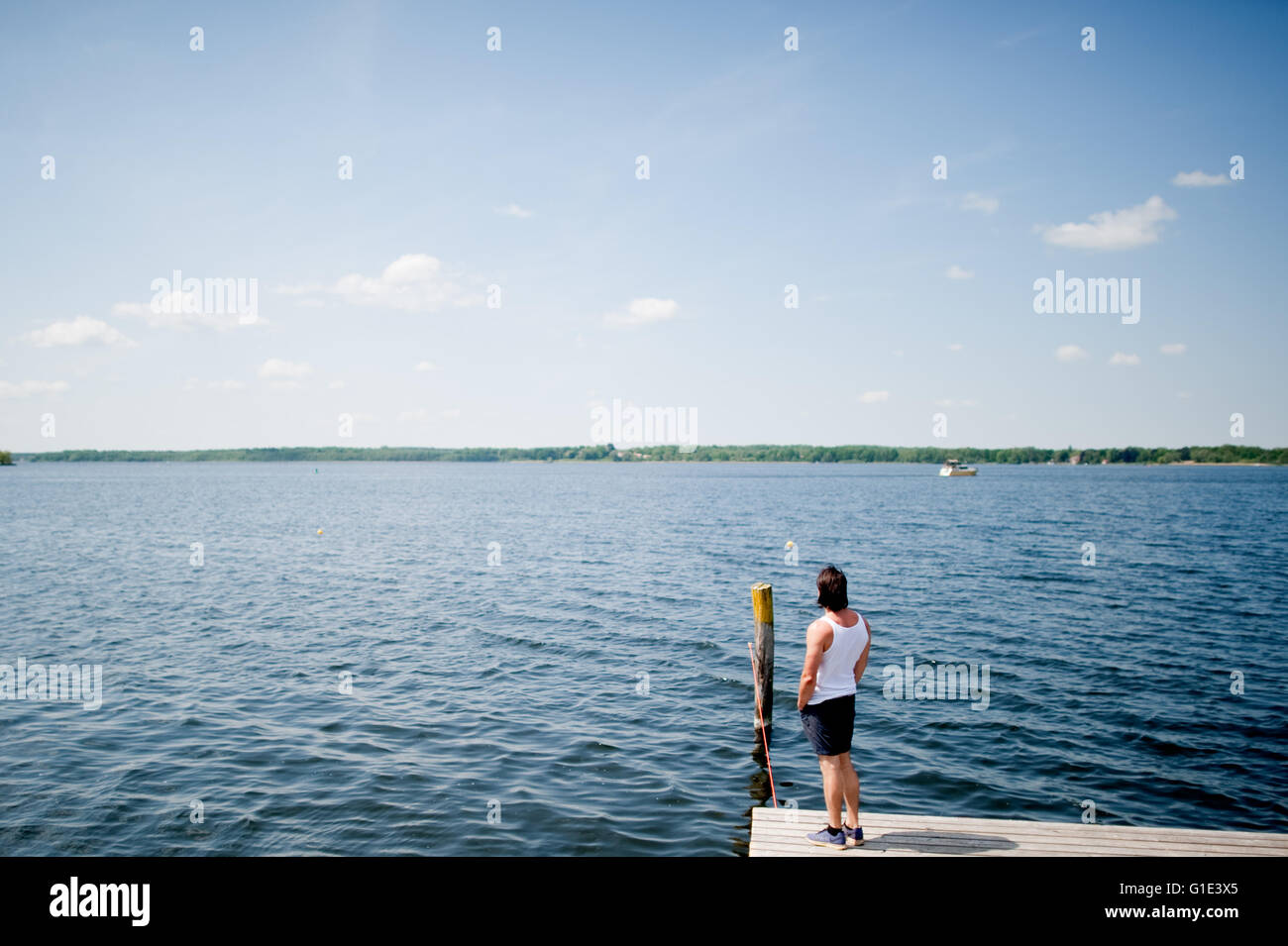 Petzow, Allemagne. 13 mai, 2016. ILLUSTRATION - Un homme se tient sur un débarcadère à l'Caputh lido et donne sur le lac Schwielowsee de Petzow, Allemagne, 13 mai 2016. La qualité de l'eau de tous les 251 lacs de baignade est excellente selon le ministère de l'consommateurs de Brandebourg. Photo : Klaus-Dietmar Gabbert/dpa/Alamy Live News Banque D'Images