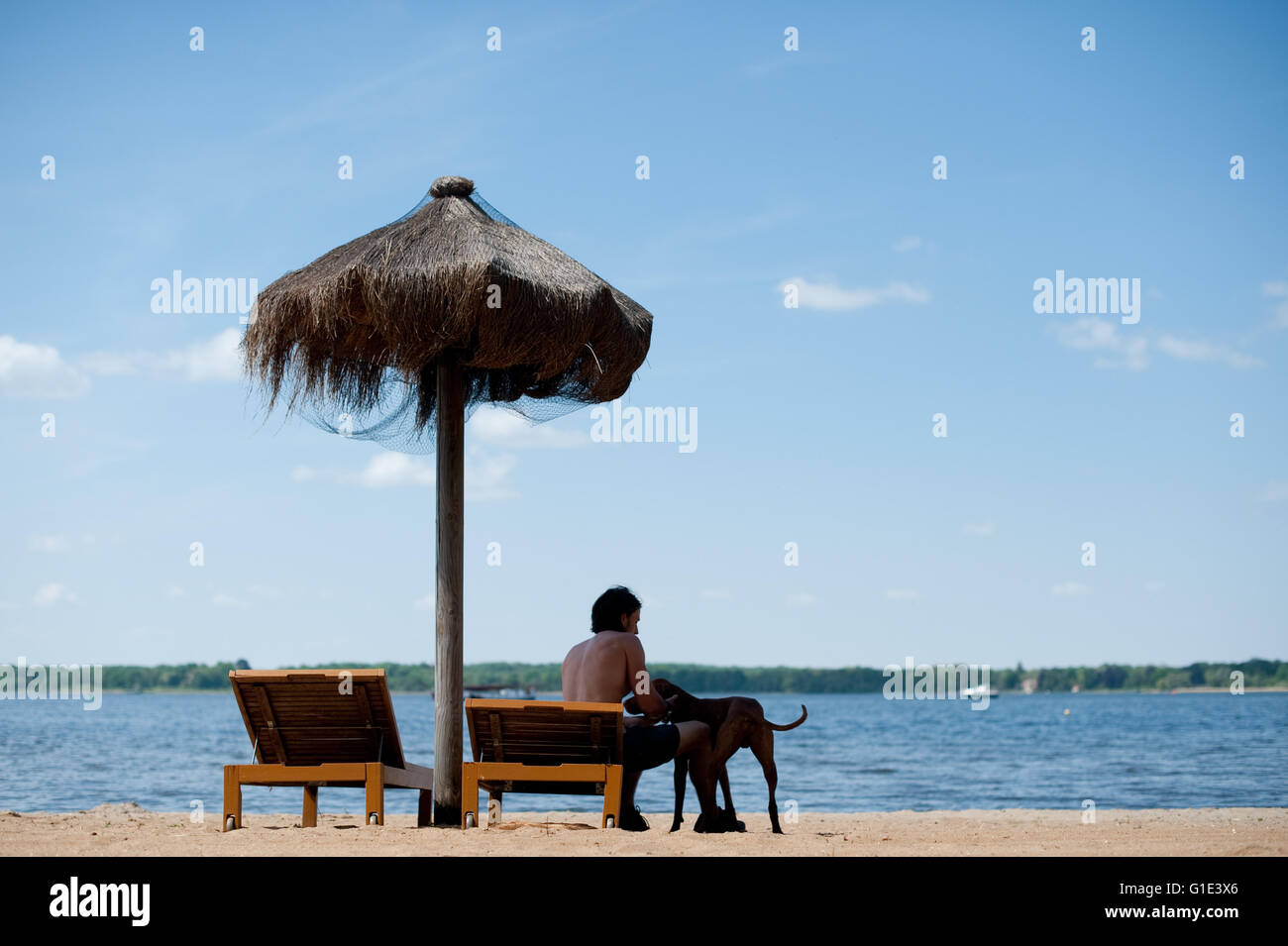 Petzow, Allemagne. 13 mai, 2016. ILLUSTRATION - Un homme est assis sur une chaise de plage avec son chien à côté de lui à l'Caputh lido et donne sur le lac Schwielowsee de Petzow, Allemagne, 13 mai 2016. La qualité de l'eau de tous les 251 lacs de baignade est excellente selon le ministère de l'consommateurs de Brandebourg. Photo : Klaus-Dietmar Gabbert/dpa/Alamy Live News Banque D'Images