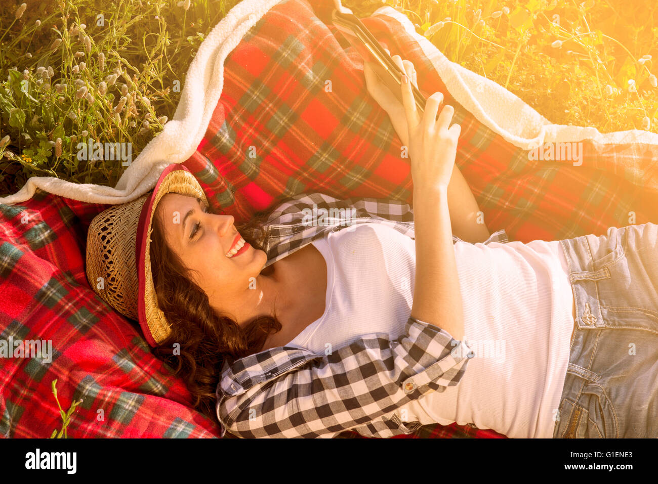 Fille lit un cachet dans la nature sur une couverture Banque D'Images