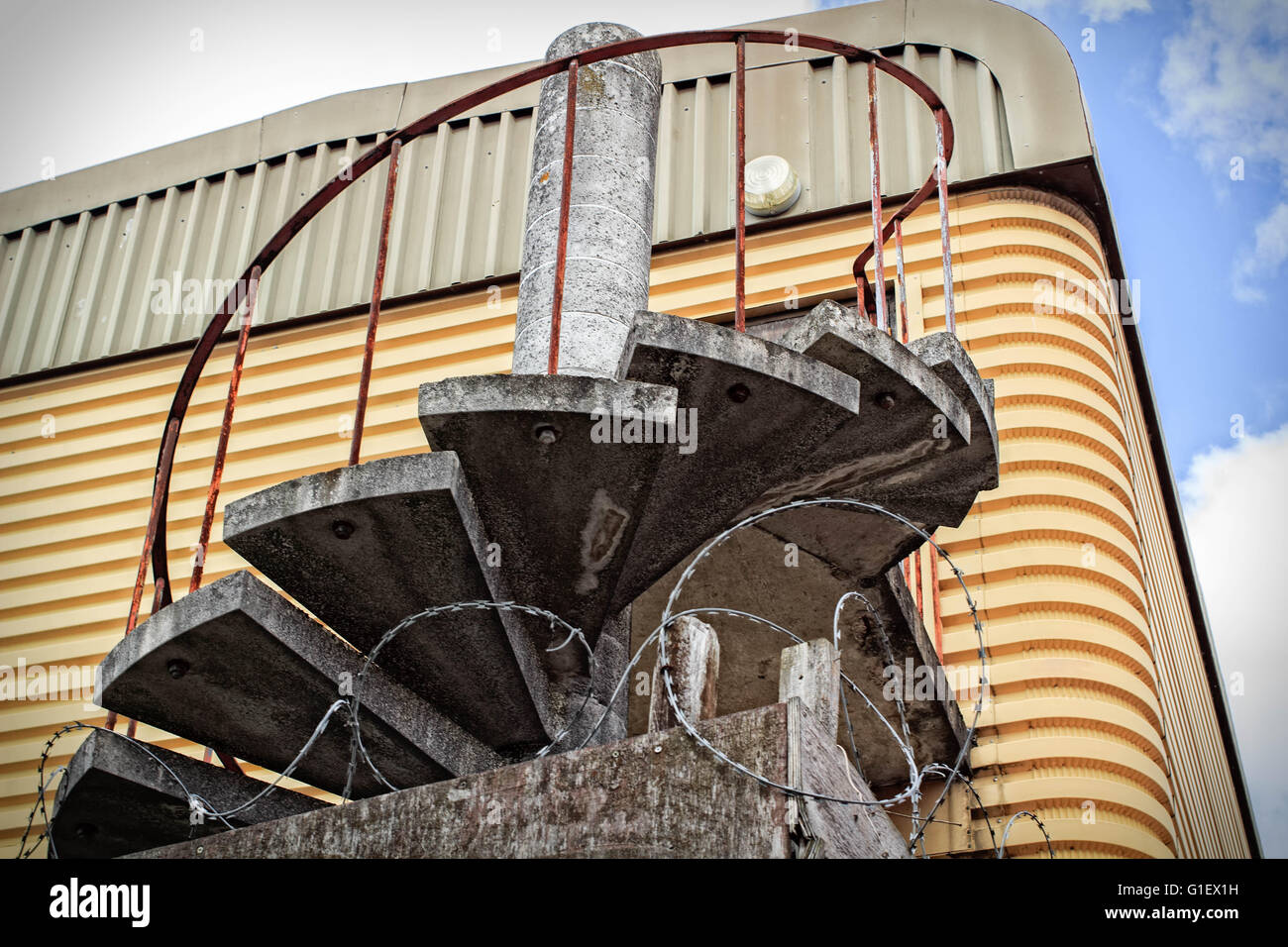 Escaliers en spirale avec fer forgé une fois utilisé comme une issue de secours sur un metal abadon warehouse Banque D'Images