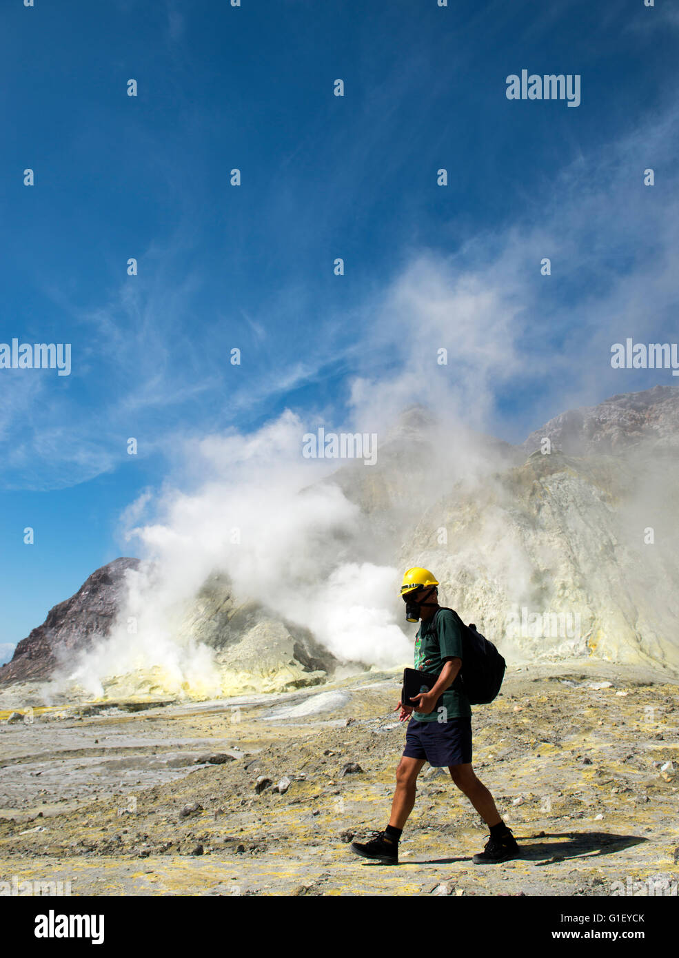 Touriste avec masque à gaz et un casque sur la terre au volcan actif Whakaari White Island Nouvelle Zélande Banque D'Images