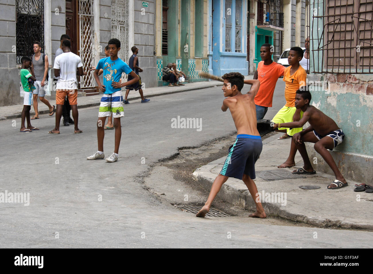 Les garçons la pratique de frapper des balles de base-ball dans la rue, La Havane, Cuba Banque D'Images