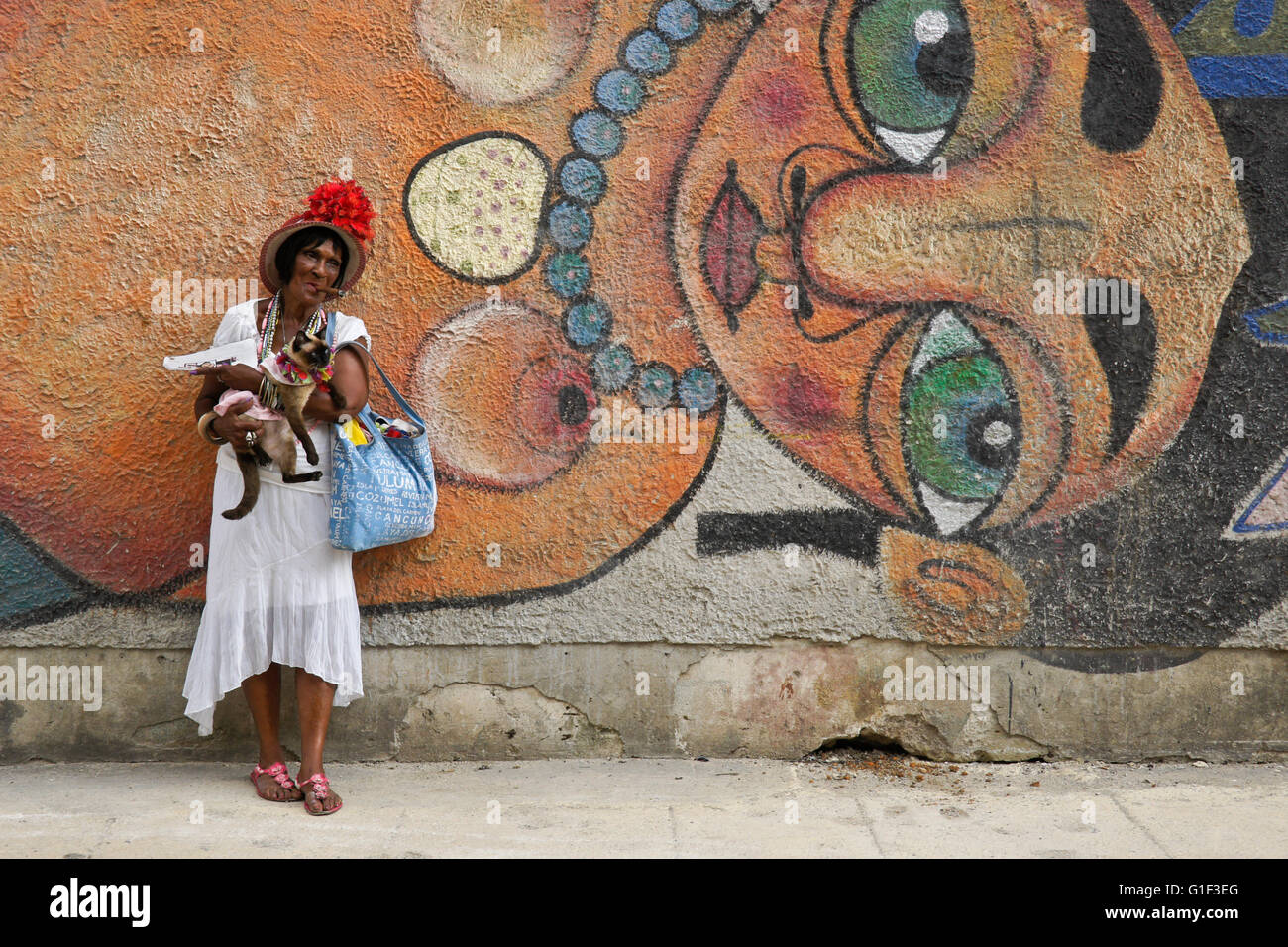 Fumeurs de cigare femme et son chat en face de fresque de rue, La Havane, Cuba Banque D'Images