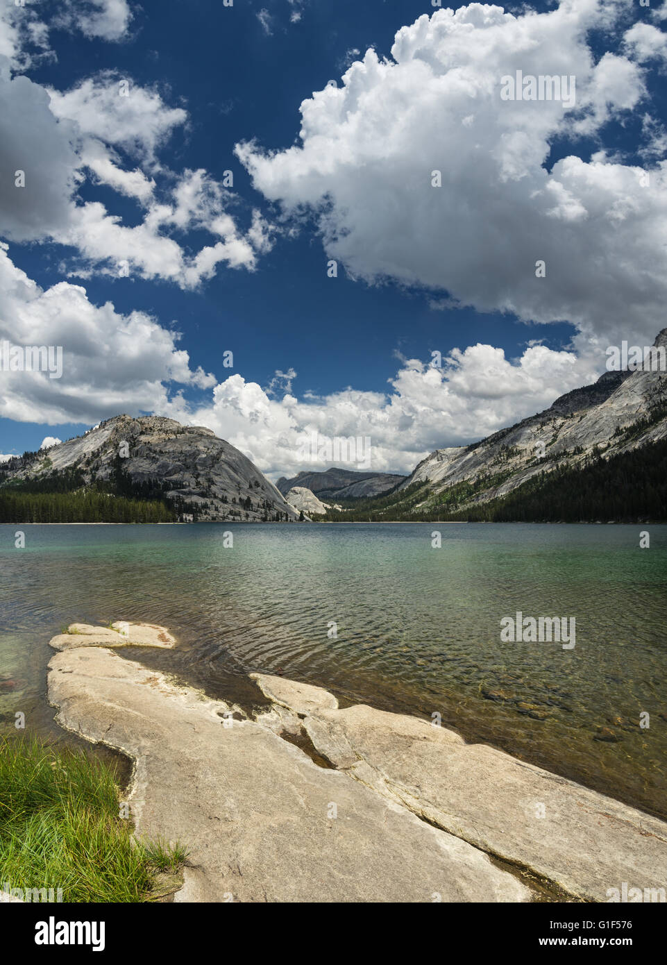 Dans le lac Tenaya Yosemite National Park high country avec plaque de roche de premier plan et les nuages blancs dans le ciel Banque D'Images