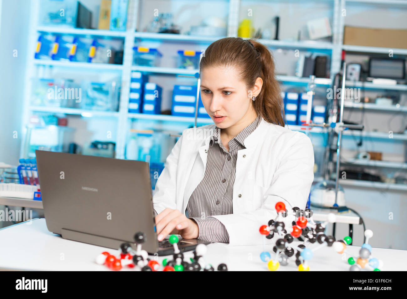 Parution du modèle. Female scientist using laptop dans le laboratoire. Banque D'Images
