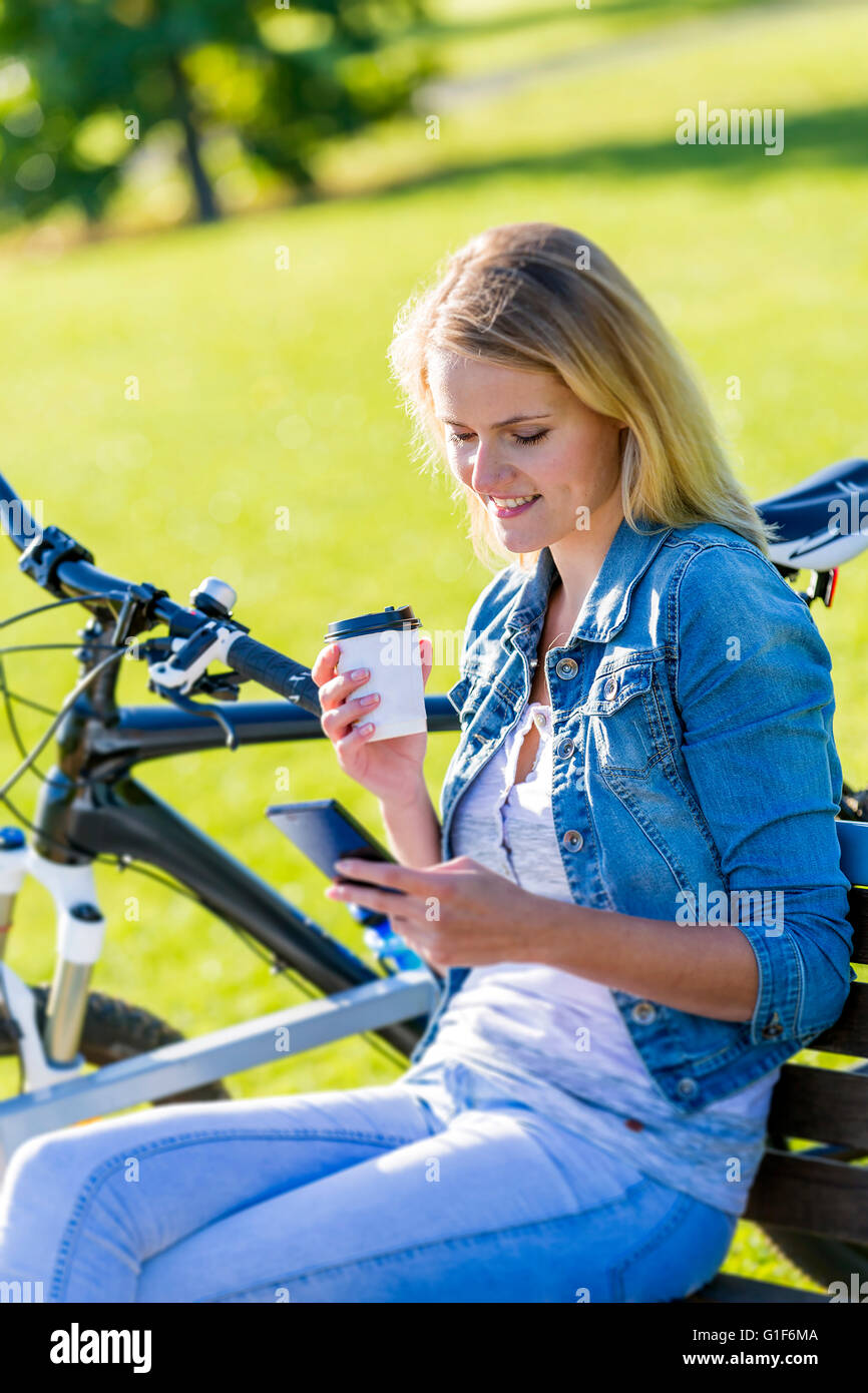 Parution du modèle. Young woman using cell phone avec du café. Banque D'Images