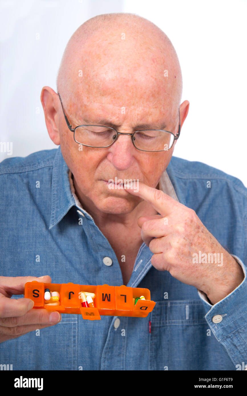 Parution du modèle. Senior man holding a pill organizer. Banque D'Images