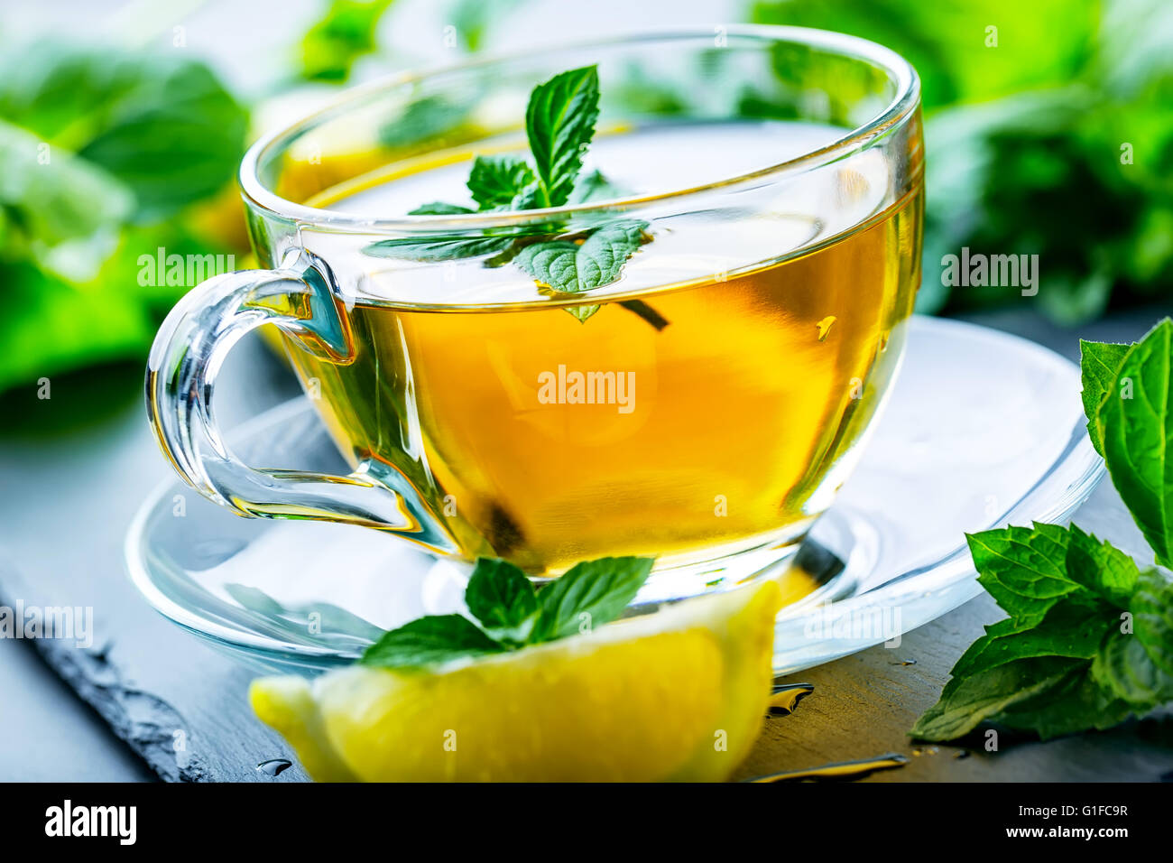 Le thé. Thé à la menthe. Tisane. Feuille de menthe. Les feuilles de menthe. Du thé dans une tasse en verre, les feuilles de menthe, thé séché, des tranches de citron vert et menthe thé herbes. l Banque D'Images