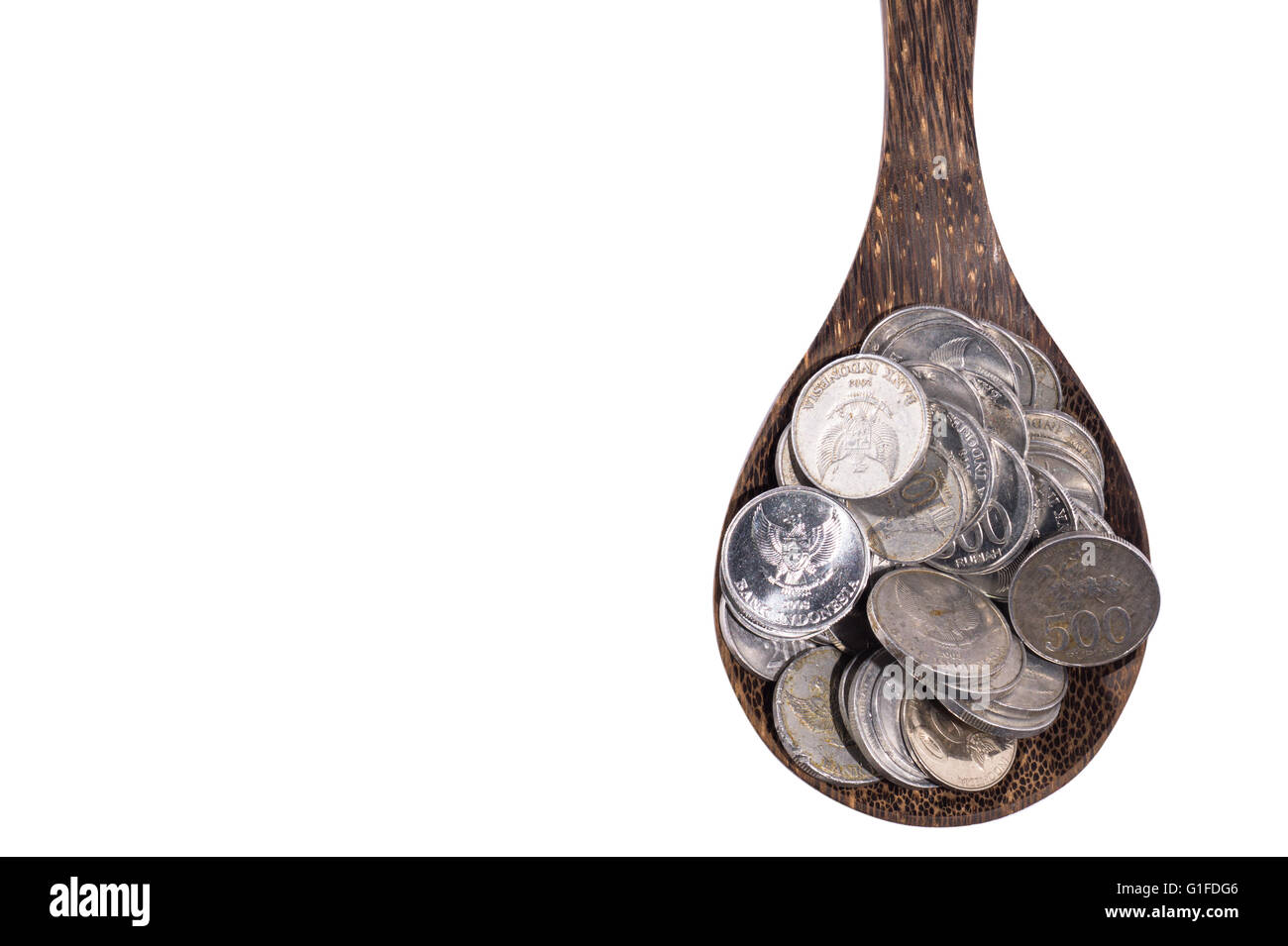 Pile de coins isolés sur cuillère en bois sur fond blanc Banque D'Images