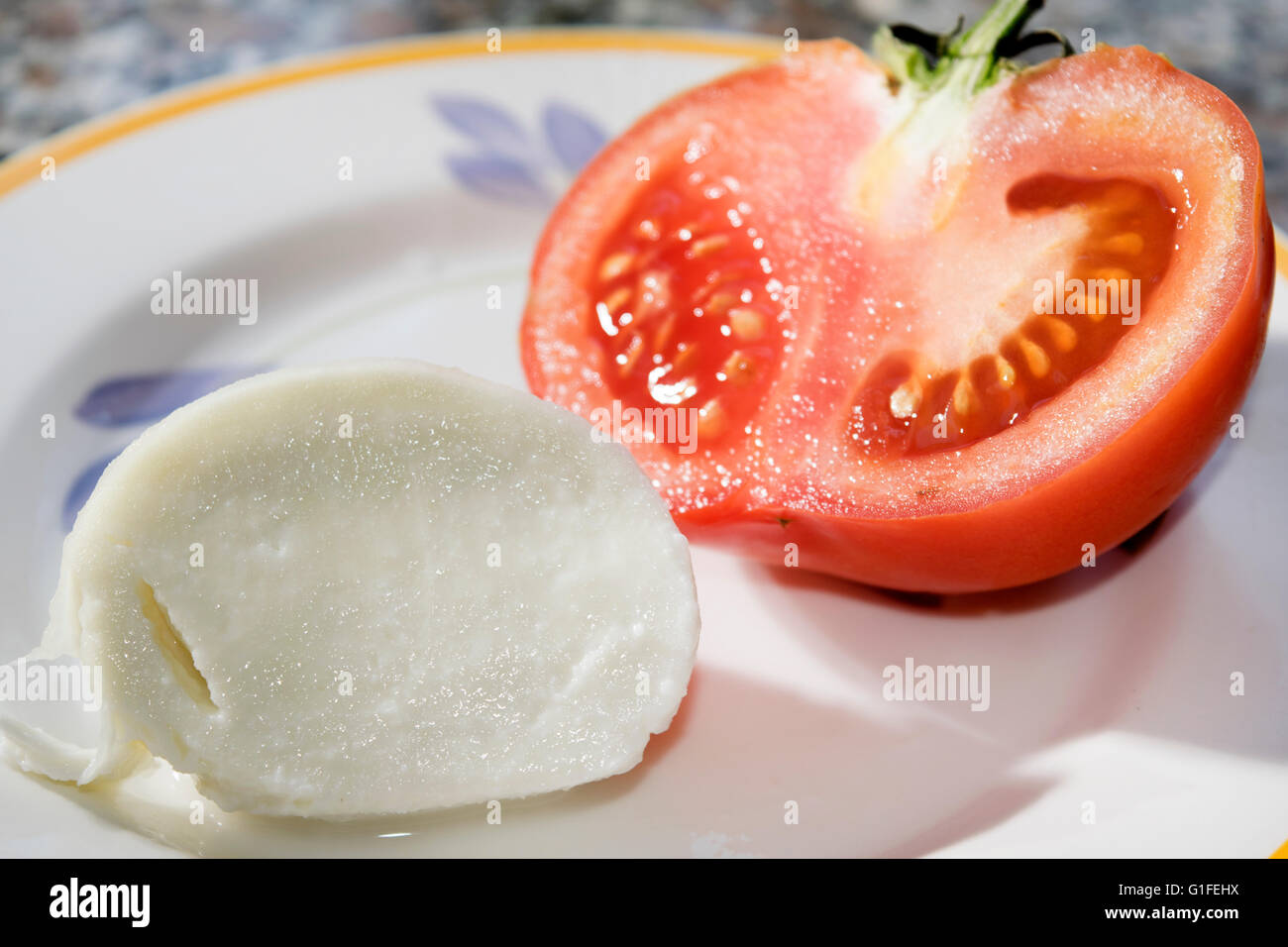 Couper la moitié des tomates fraîches et de mozzarella Banque D'Images