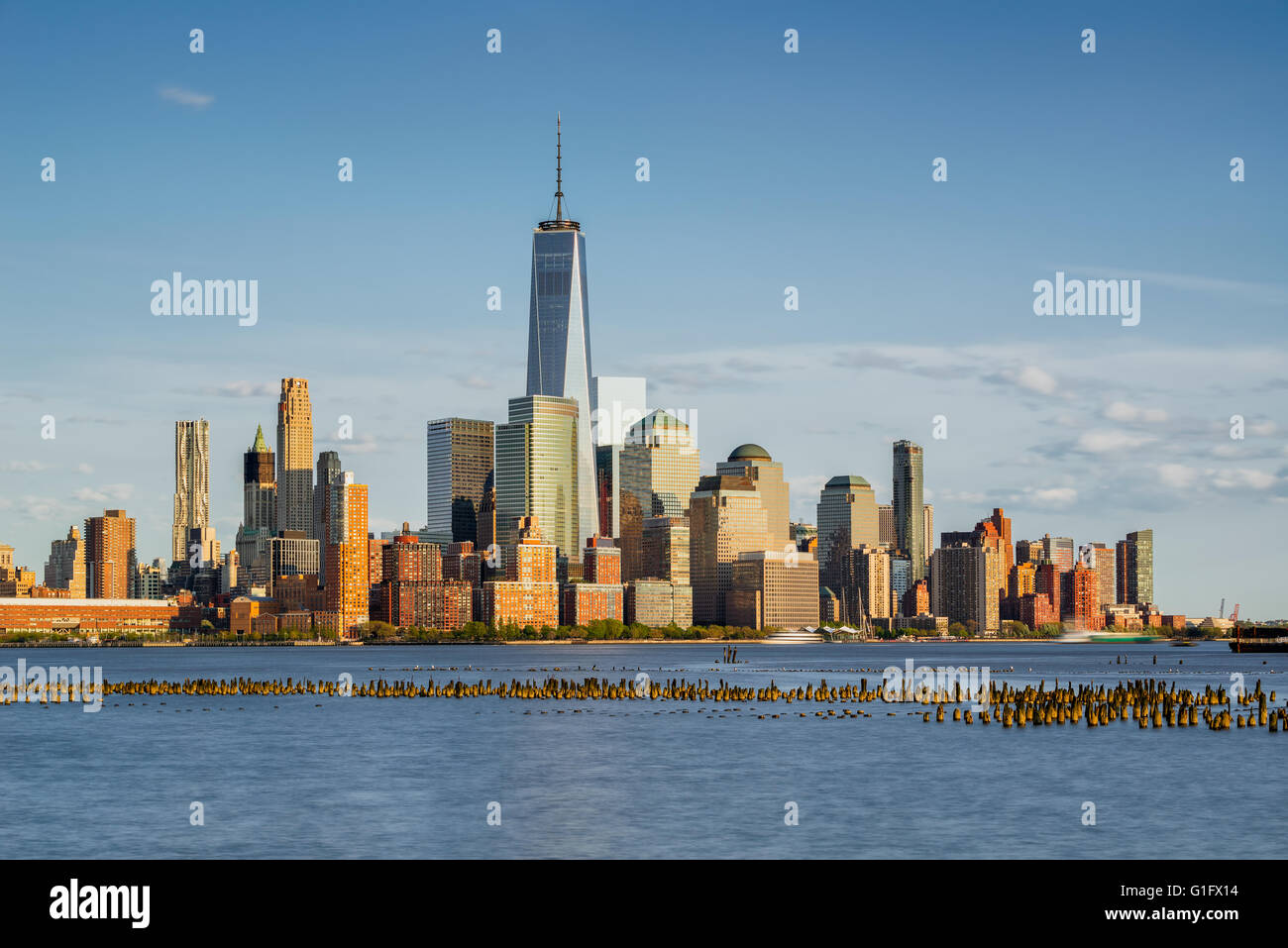 New York Ville Manhattan gratte-ciels du quartier financier et de la rivière Hudson avec des pieux en bois au coucher du soleil Banque D'Images