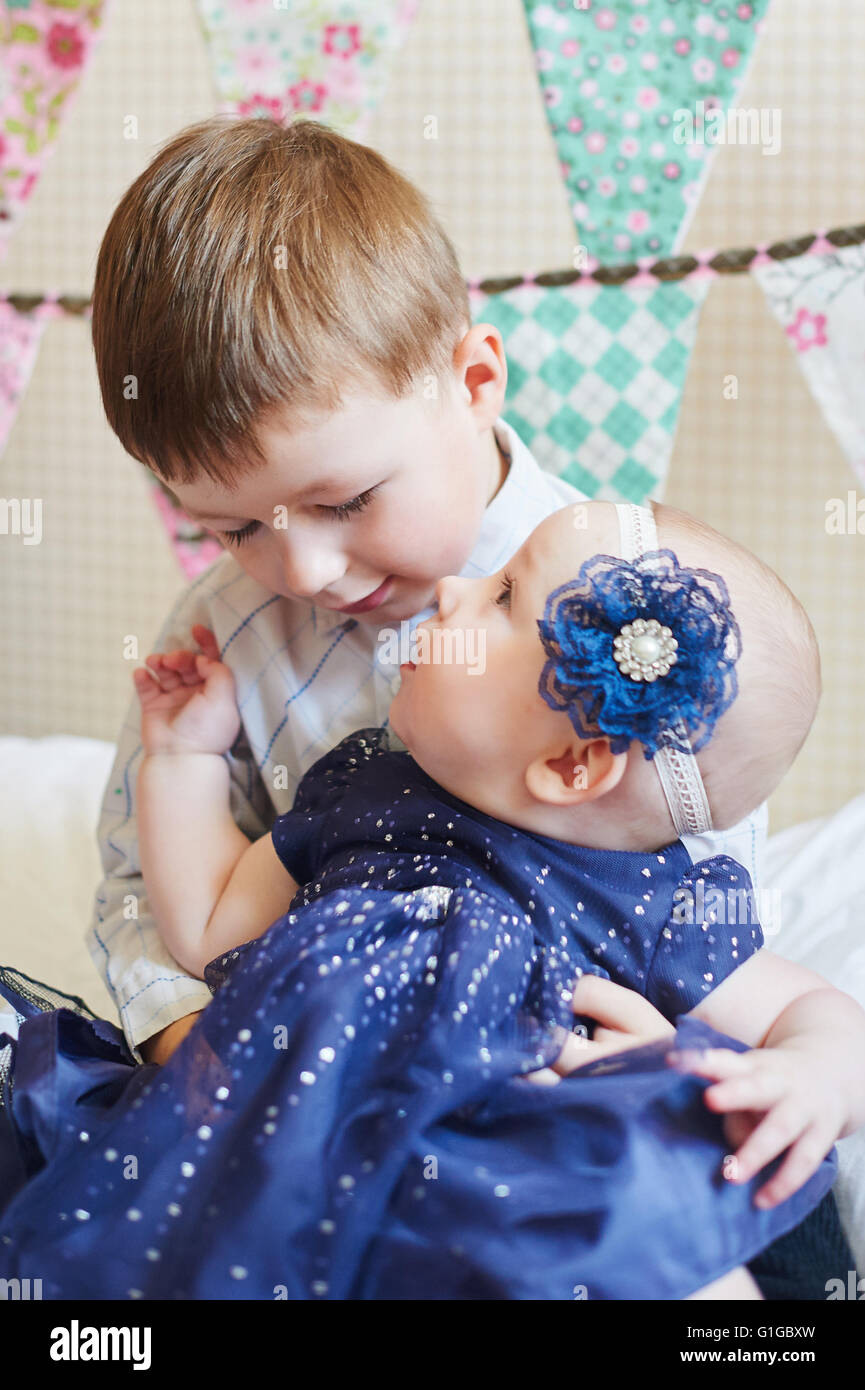 Heureux Petit Garçon jouant avec un bébé, sa sœur à l'intérieur Banque D'Images