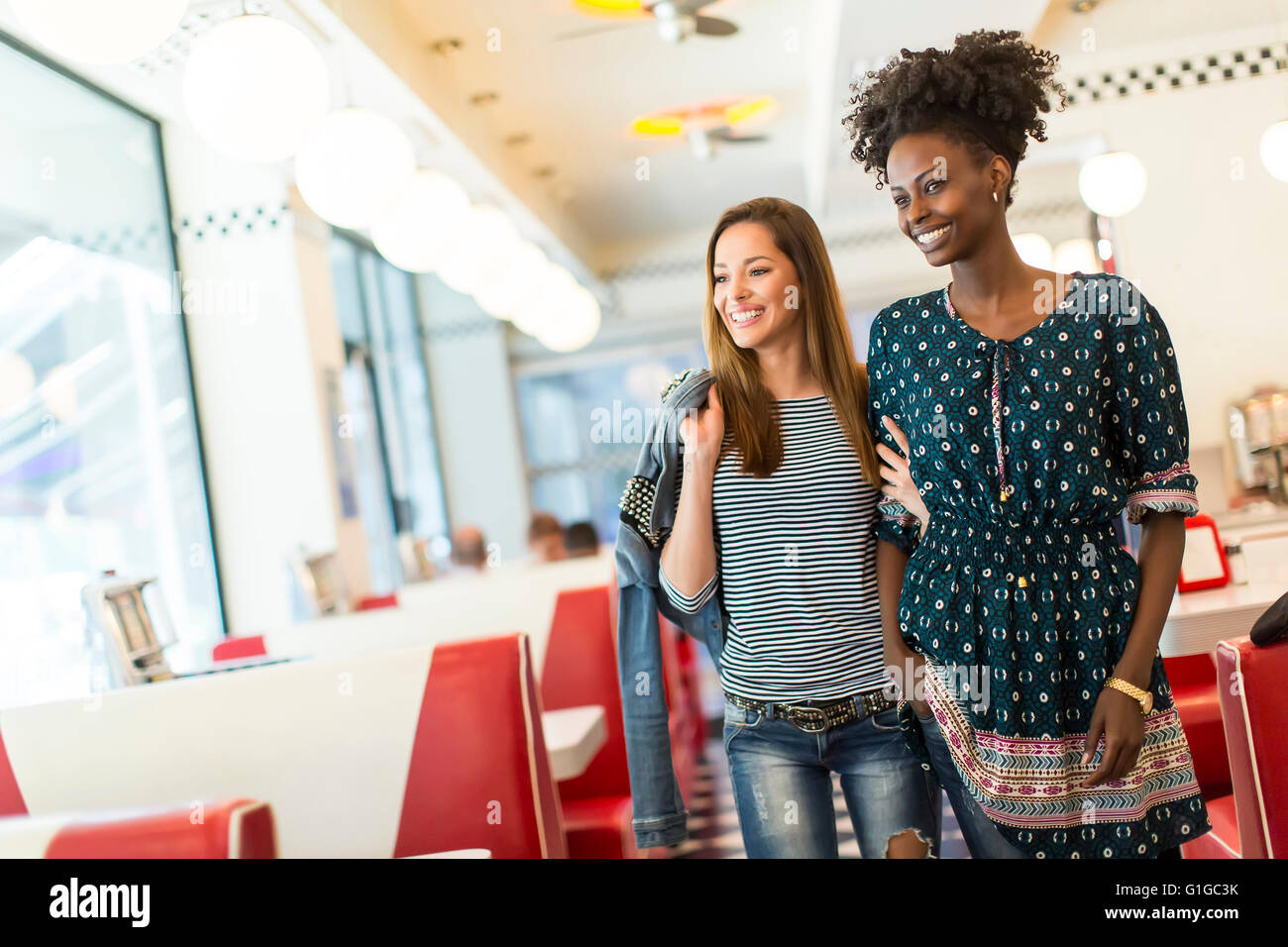 Deux jeunes femmes à socialiser dans la salle à manger Banque D'Images