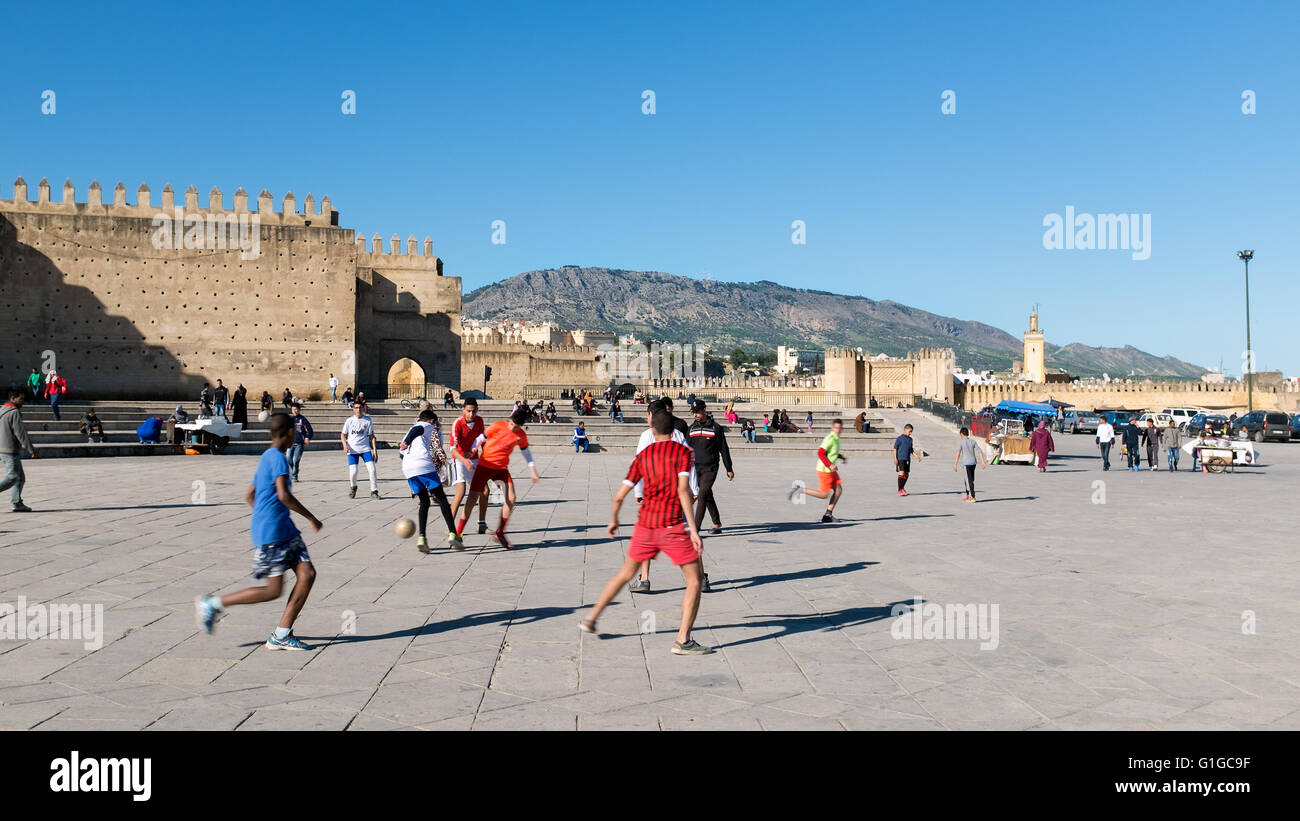 Les garçons jouent au football dans un carré de Fes, Maroc Banque D'Images