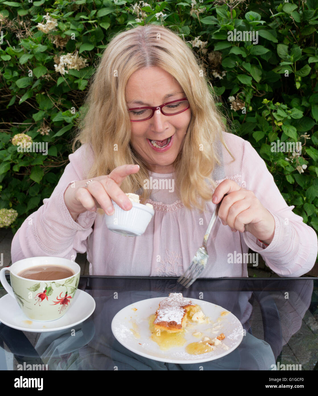 Woman eating cake avec tasse de café Banque D'Images