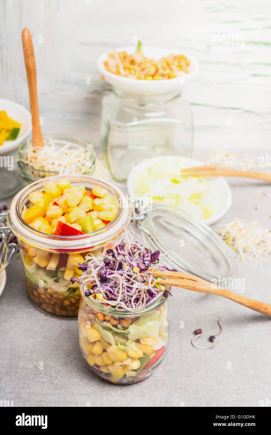 Salades de légumes savoureux en pots avec le maïs et les graines germées sur la lumière cuisine rustique table, Close up. Mode de vie sain ou alimentation nourriture Banque D'Images