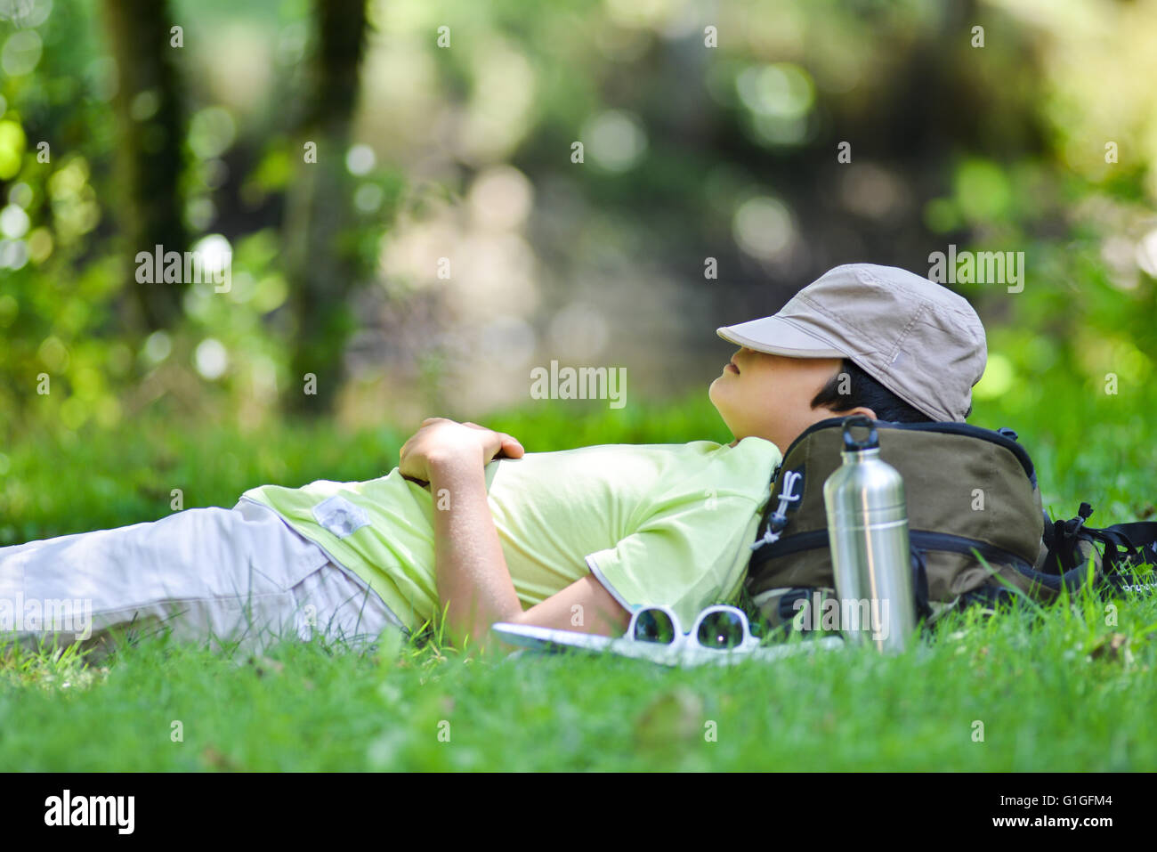 Jeune garçon allongé dans l'herbe dormir, France Banque D'Images