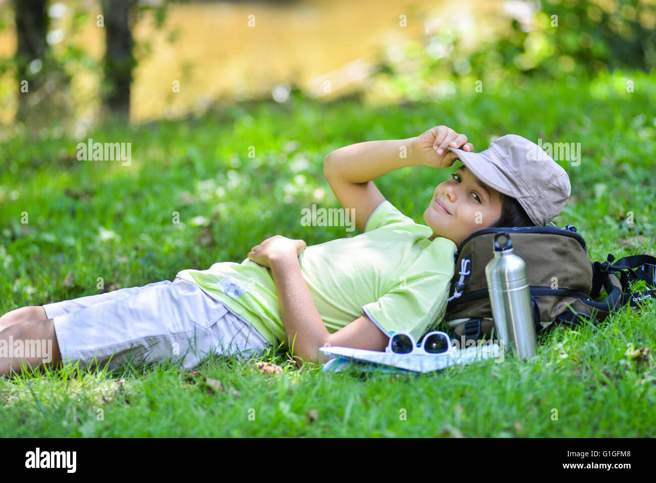 Jeune garçon allongé dans l'herbe dormir, France Banque D'Images