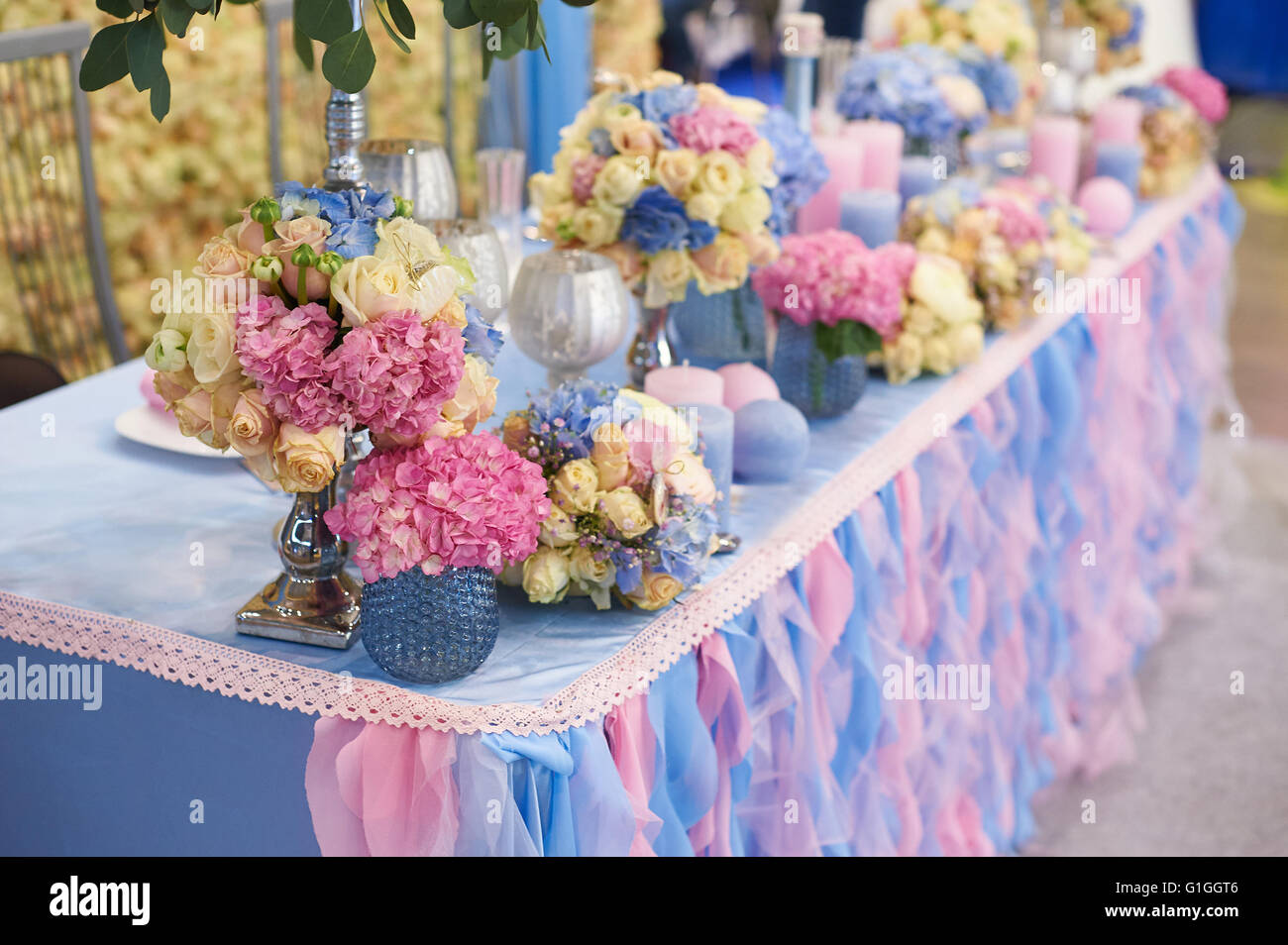 Set de table pour réception de mariage avec des bougies et bouquets de