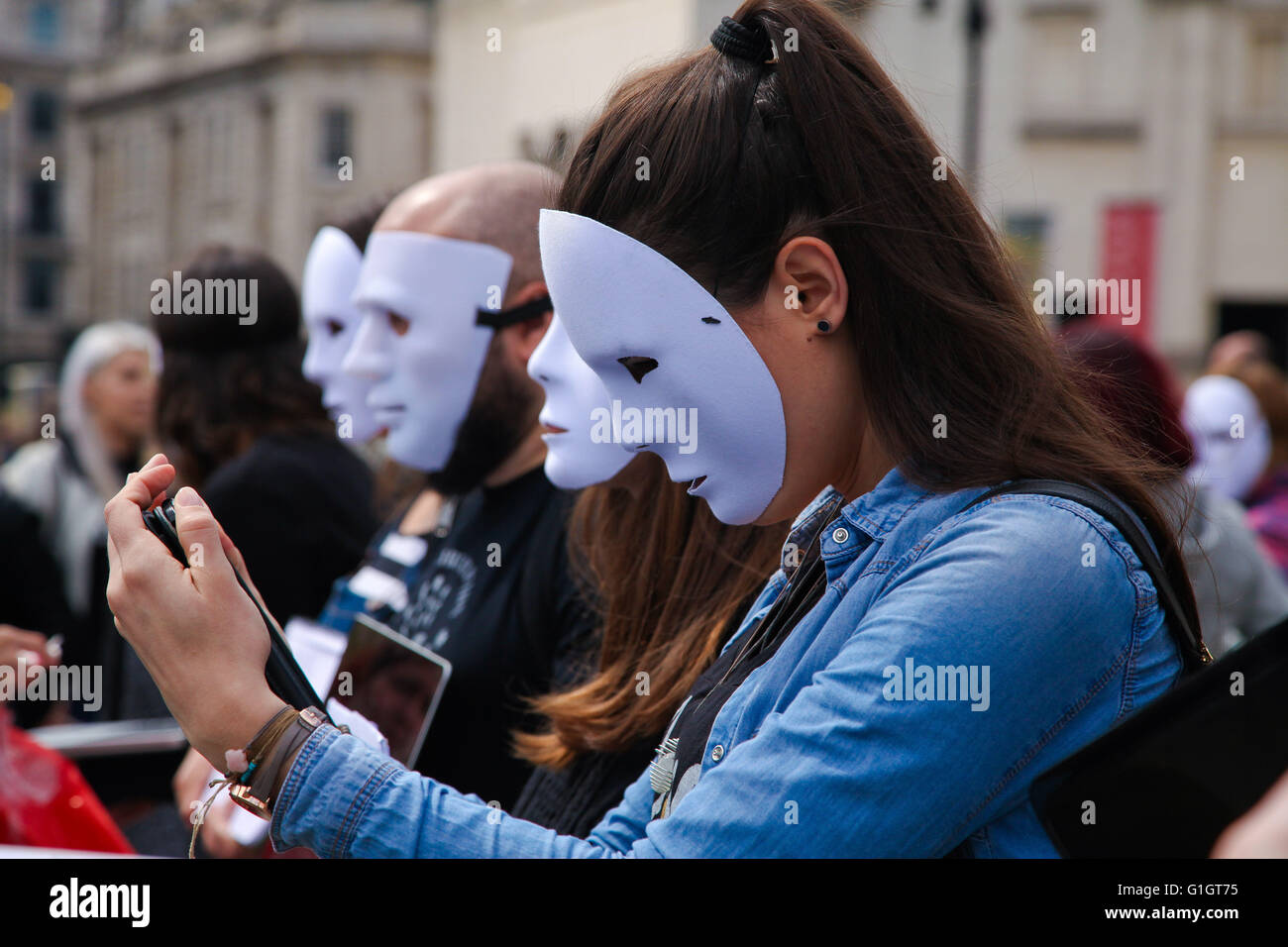 Trafalgar Square, London, UK 14 mai 2016 - Un groupe d'activistes végétaliens Londres International terriens expérience jour à Trafalgar Square pour créer des changements positifs pour tous les Terriens. Les manifestants se tenir en masques blancs et tenant des pancartes ou des ordinateurs portables, sur lequel le film est joué. Faites par les végétaliens, il montre des scènes horribles souvent prises à l'aide de caméras cachées de pratiques cruelles dans l'industrie alimentaire et d'autres moyens que les animaux sont maltraités comme animaux domestiques, pour les vêtements, des divertissements et de la recherche scientifique : Crédit Dinendra Haria/Alamy Live News Banque D'Images