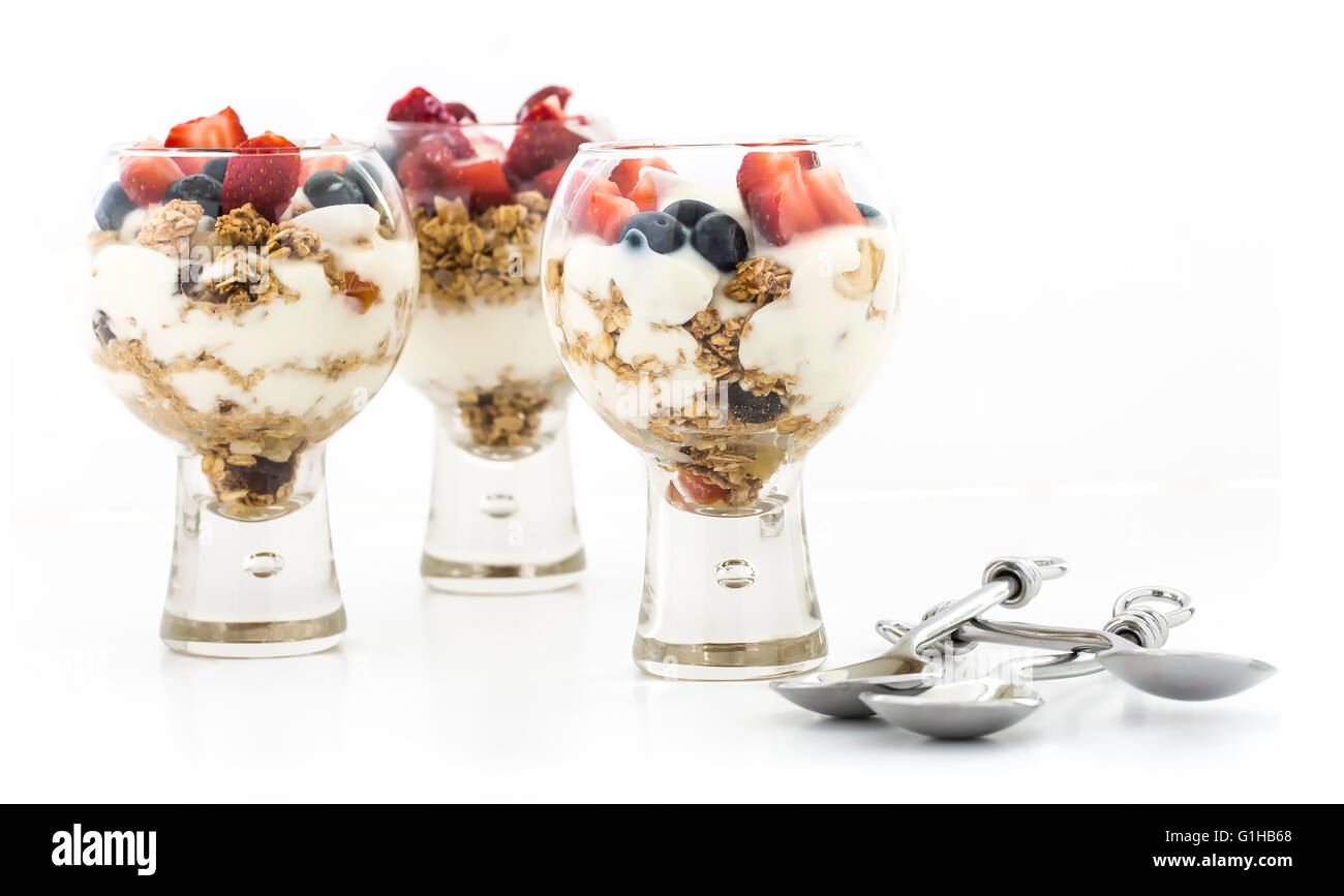 Granola Yogourt et fruits parfaits sur un fond blanc Banque D'Images