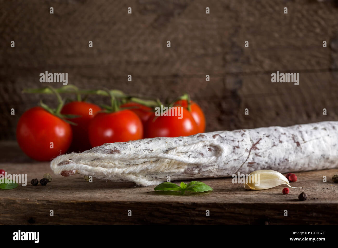 Salami italien avec des épices et des légumes sur fond de bois rustique Banque D'Images