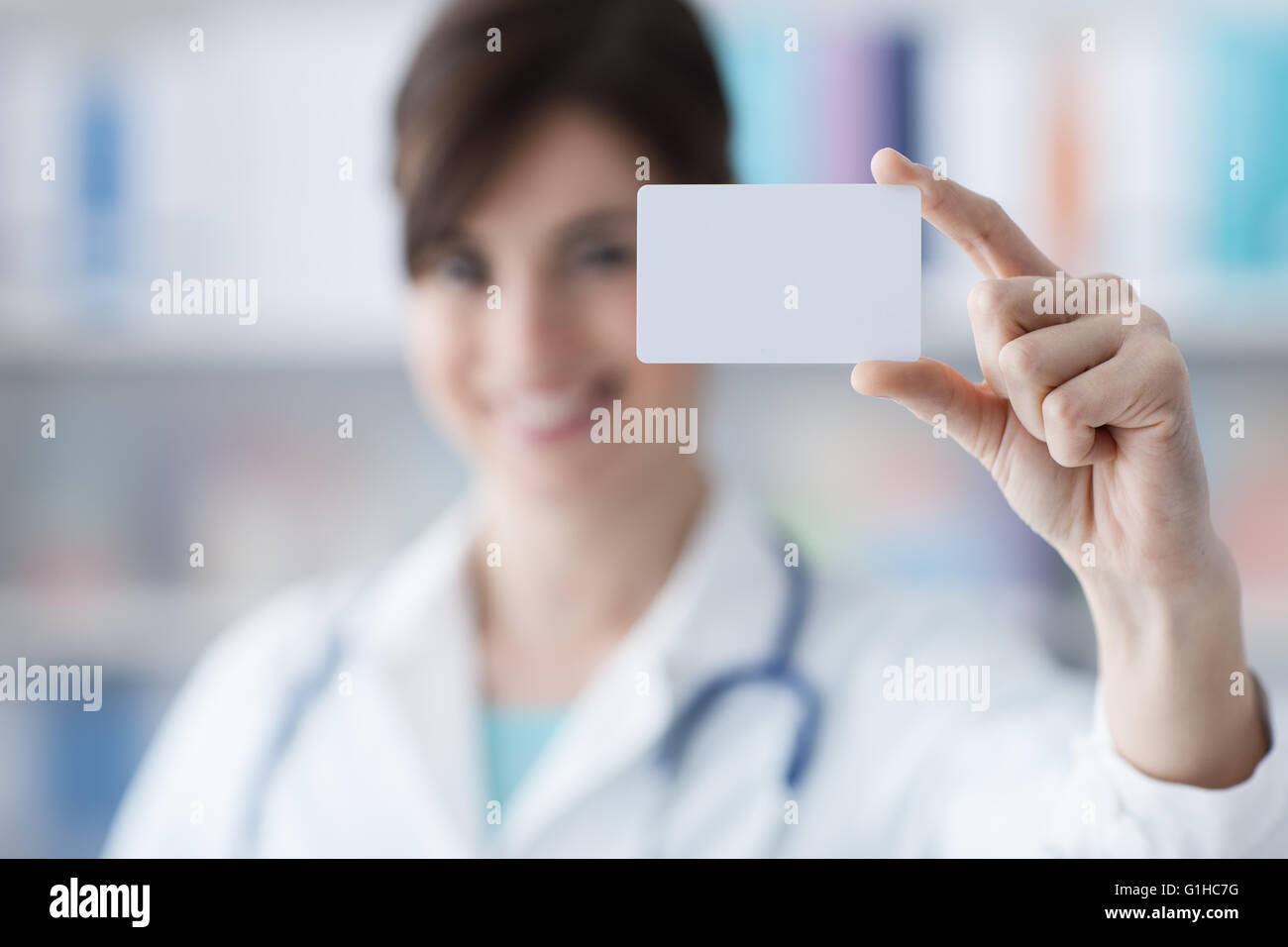 Smiling female doctor holding a blank business card, de la santé et de l'entreprise Banque D'Images