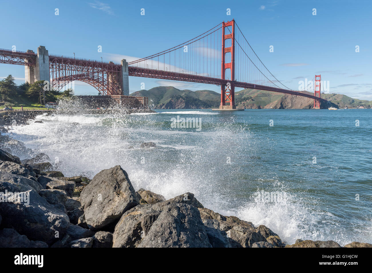 Vagues se brisant sur le rivage de la baie de San Francisco, avec le Golden Gate Bridge en arrière-plan. Californie, USA. Banque D'Images