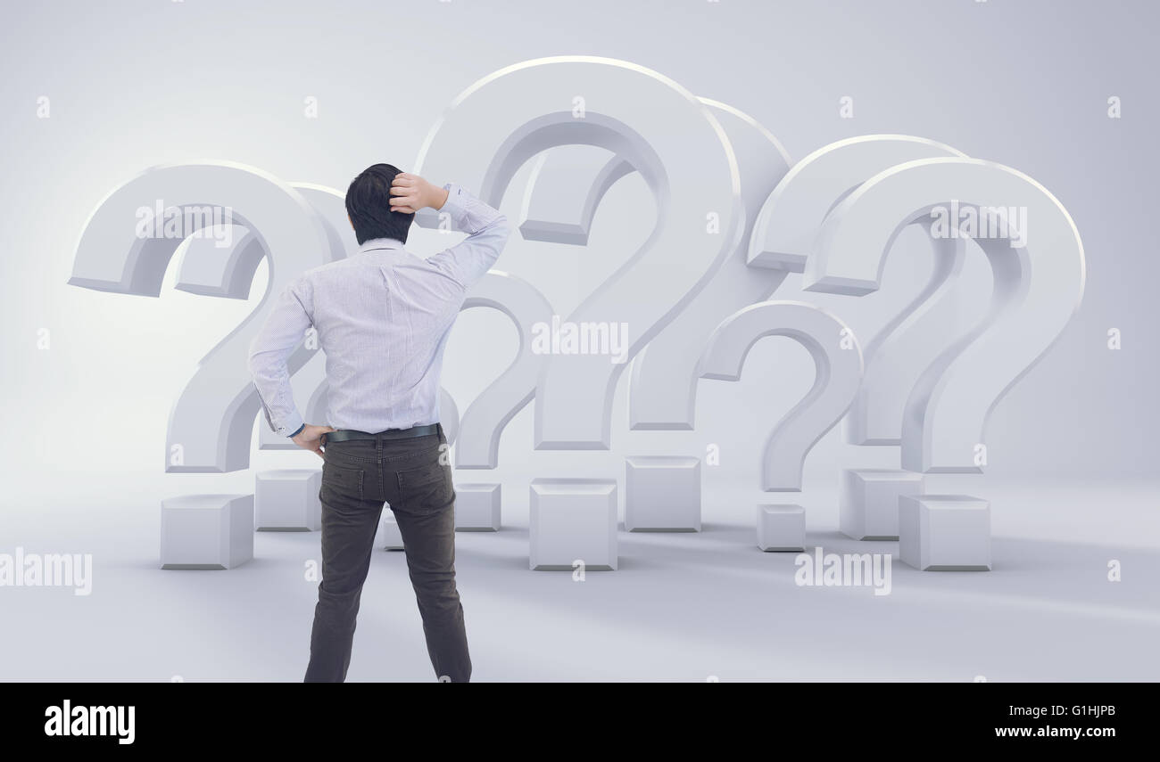 Asian Man Standing In front of Big Question Mark Banque D'Images