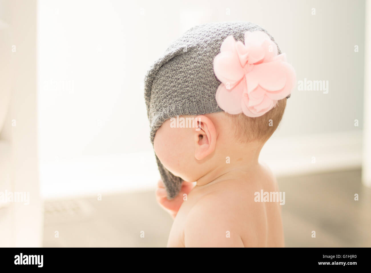 La moitié des Asiatiques tirant son bébé avec chapeau gris rose fleur off Banque D'Images