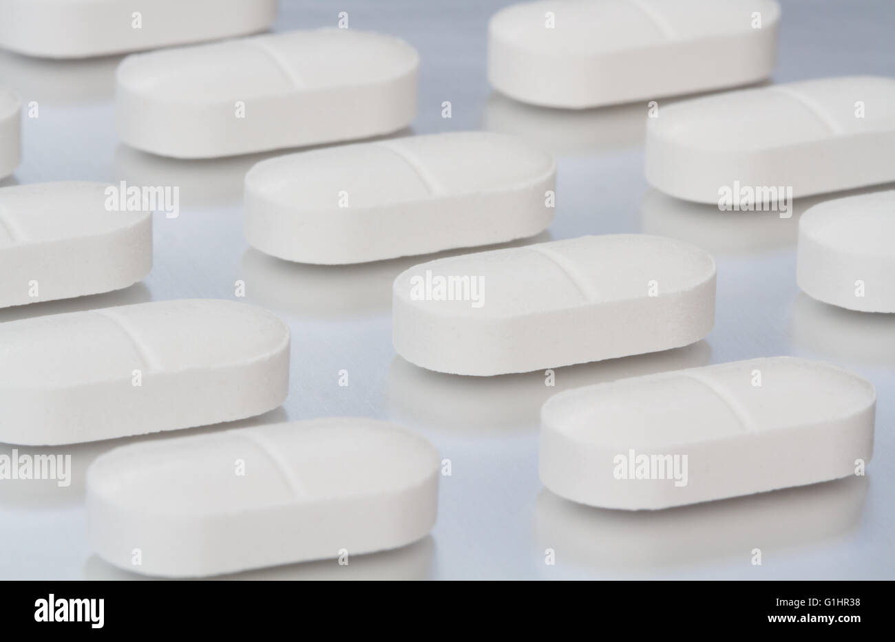 Rangs de perles, le soulagement de la douleur sur une tablette surface de métal brillant dans une image de la fabrication de produits pharmaceutiques. Banque D'Images