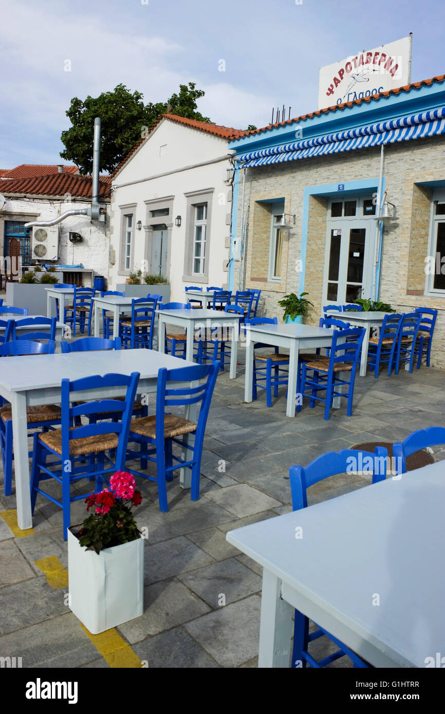 Rangées de tables de taverne vide cyan bleu avec des chaises. Restaurant Glaros, Waterfront de Myrina city ,Limnos ou Lemnos, Grèce Banque D'Images