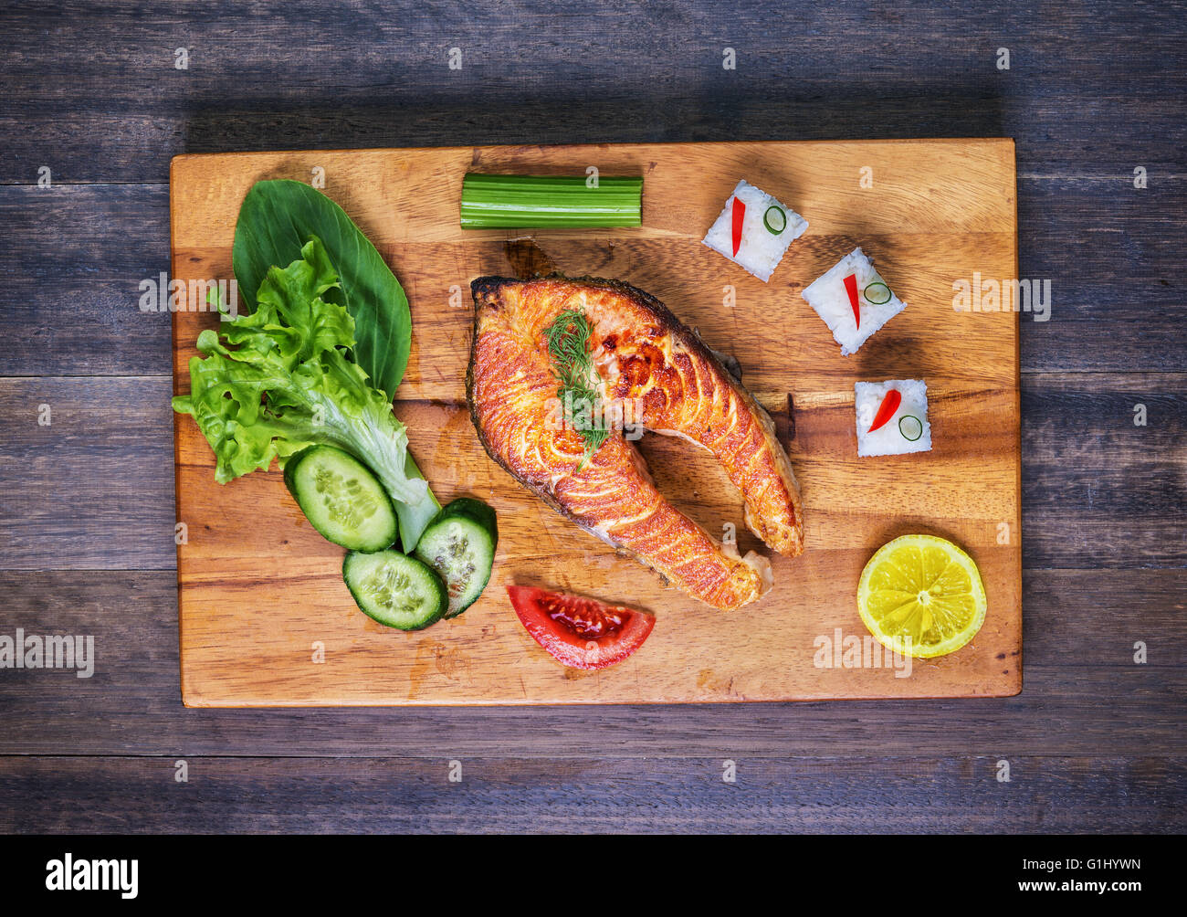 Saumon grillé avec légumes et riz sur plaque de bois et sur la table rustique. Vue d'en haut Banque D'Images