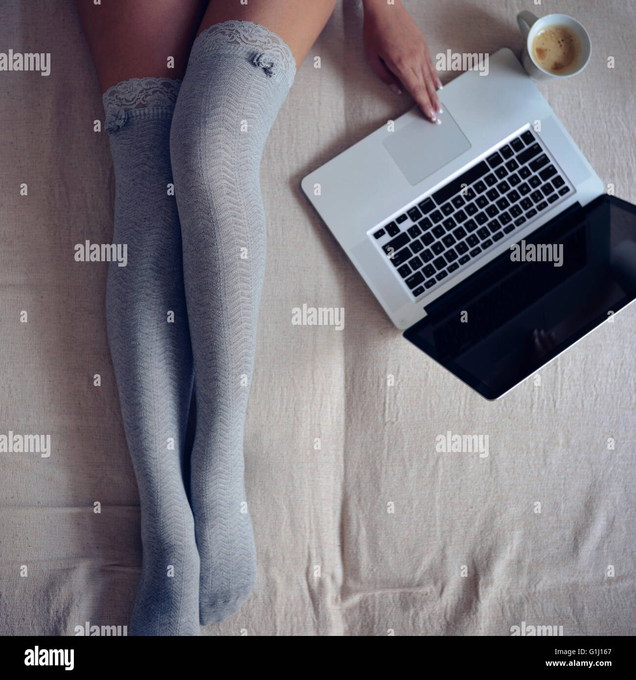 Jambes de femme dans le lit. Banque D'Images