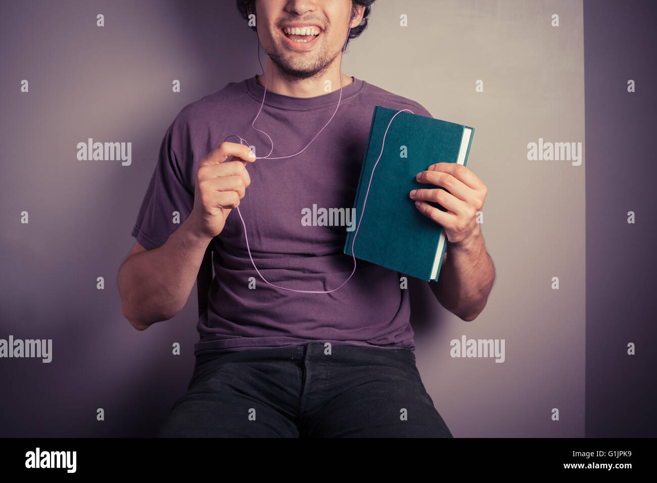 Un jeune homme est en train d'écouter un livre audio Banque D'Images