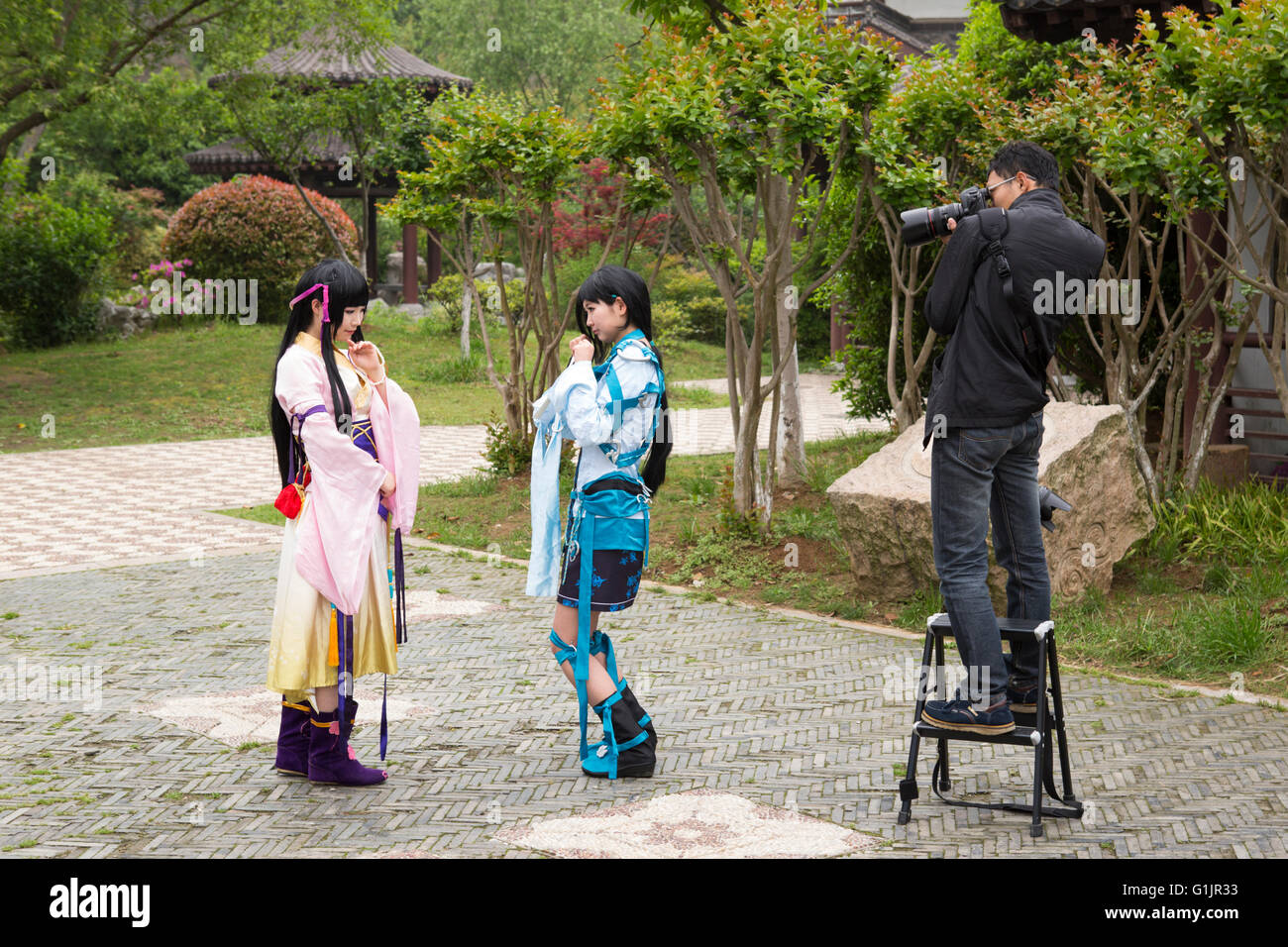 Scène avec le photographe chinois au travail avec deux modèles photo cosplay à Chaoyang Park, la culture de la jeunesse à Nanjing, Chine Banque D'Images