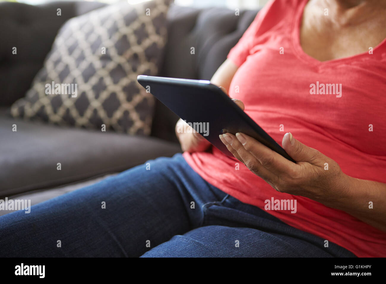 Close Up of Senior Woman On Sofa Using Digital Tablet Banque D'Images