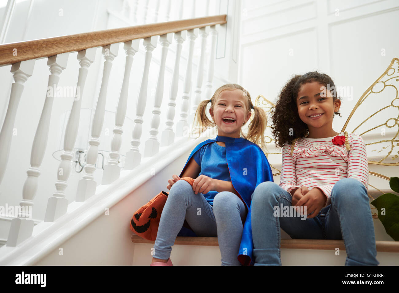Deux jeunes filles, jouant Dressing Up Games Sitting on Stairs Banque D'Images