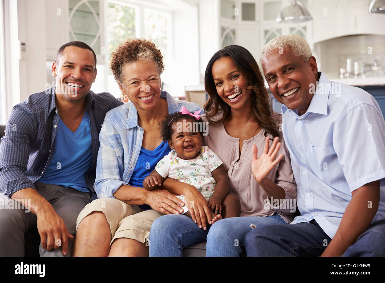 Les grands-parents et les parents avec un bébé fille sur le genou de maman Banque D'Images