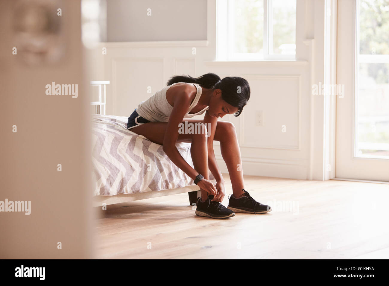Jeune femme noire prête à l'exercice de lier sa chaussure de sport Banque D'Images